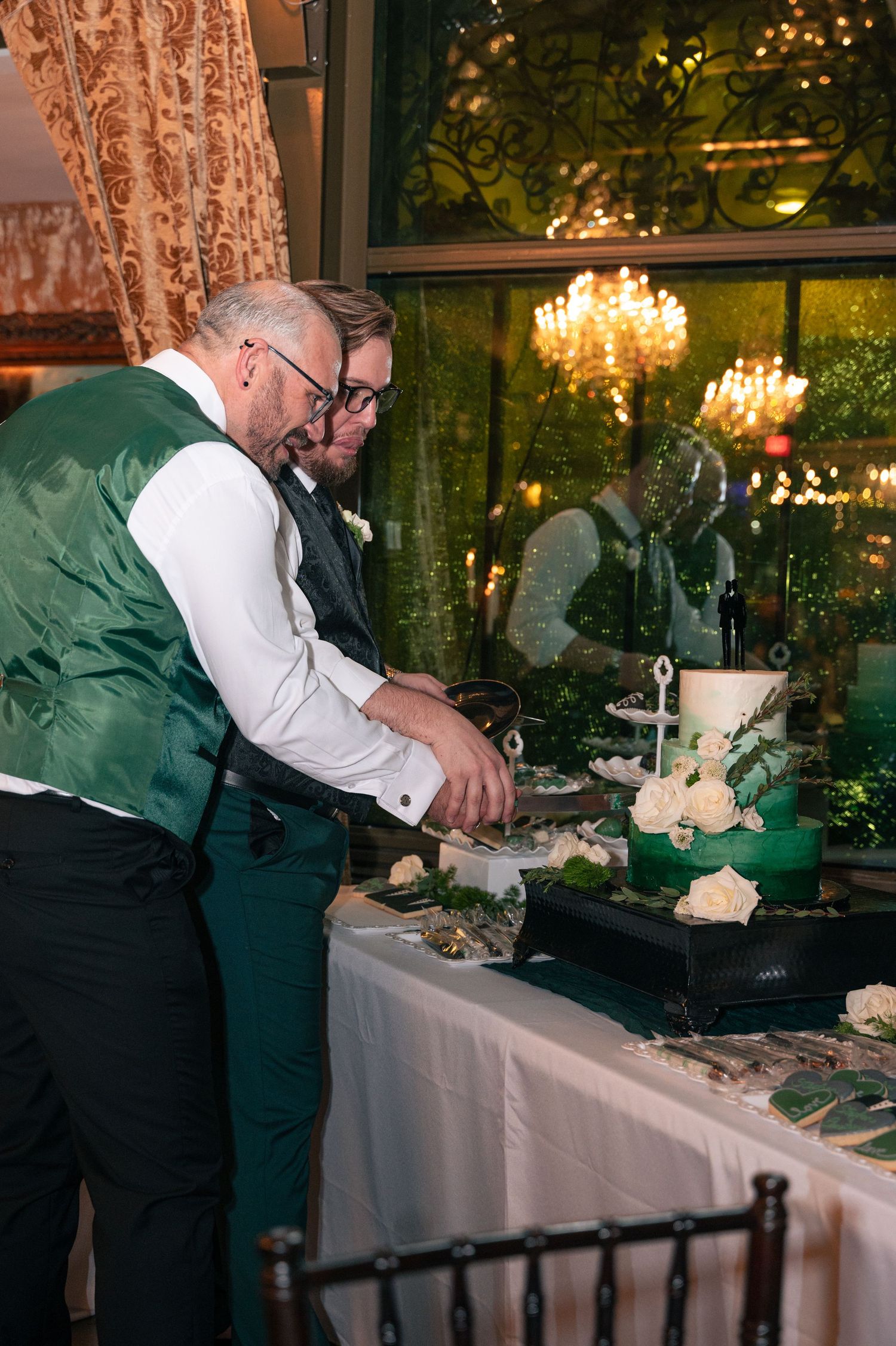 Catering staff preparing food at an elegant wedding reception buffet table.