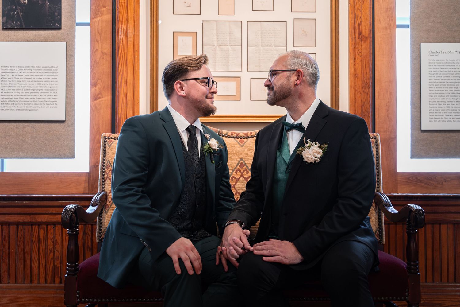 Wedding guests in formal attire seated in wooden pews during an indoor ceremony.