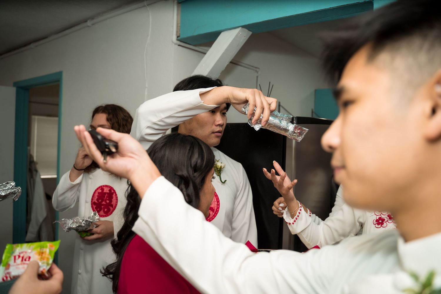 Wedding preparation candid moments captured in turquoise-walled room.