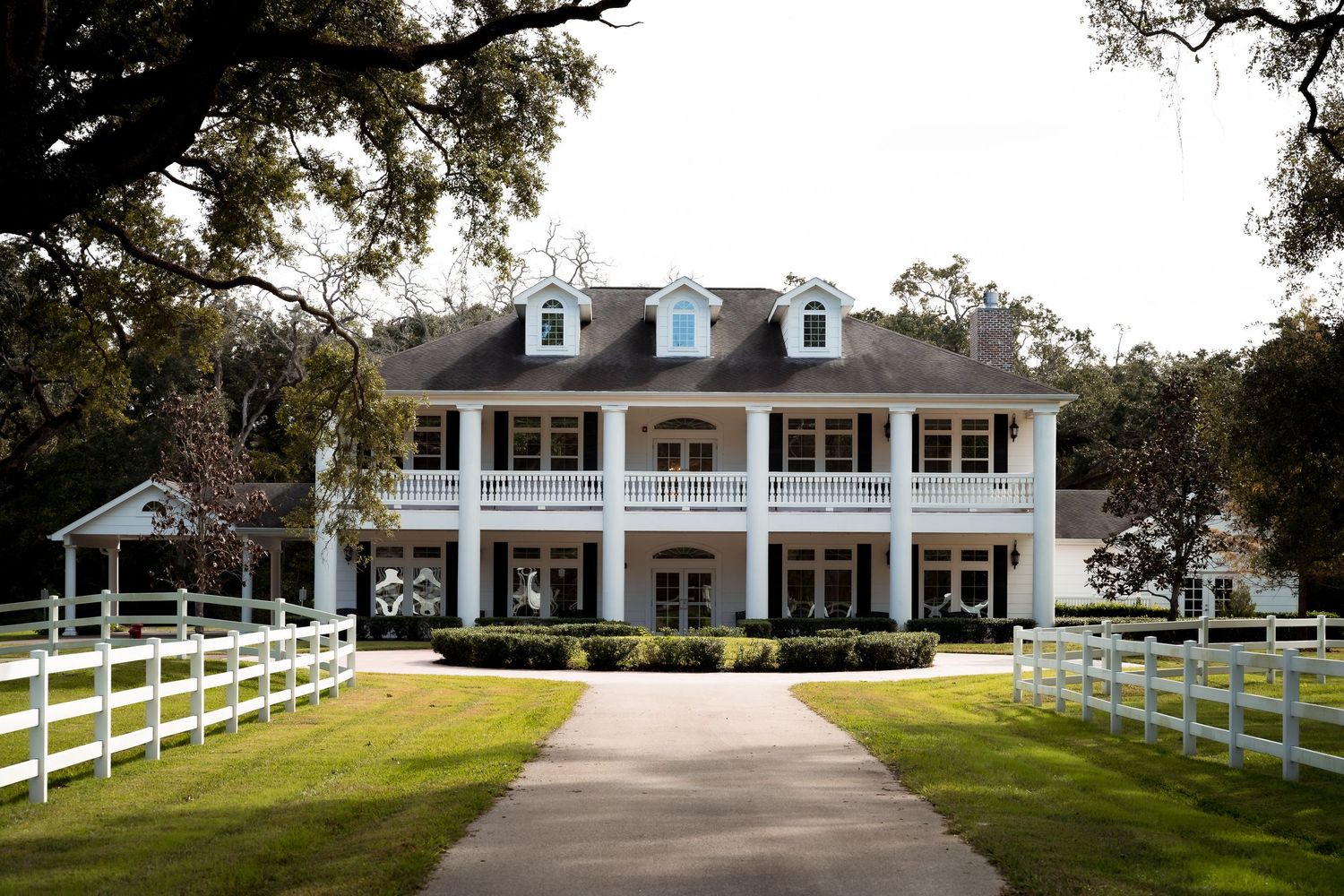 Elegant white ranch house with colonial architecture and white fence panorama.