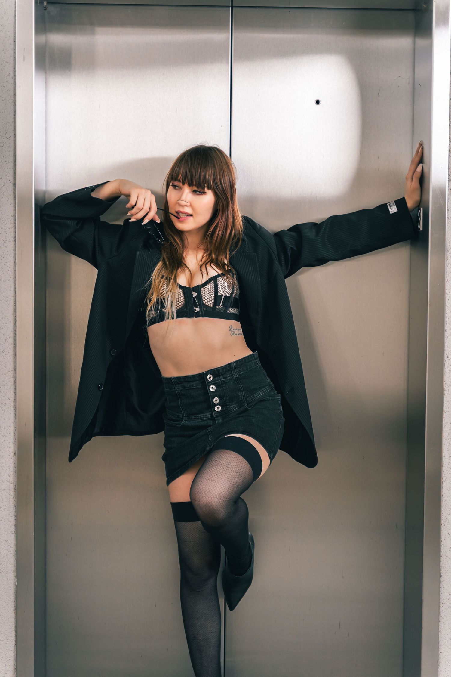 A series of artistic fashion photos showing a person in black attire posing against a white wall in different positions.