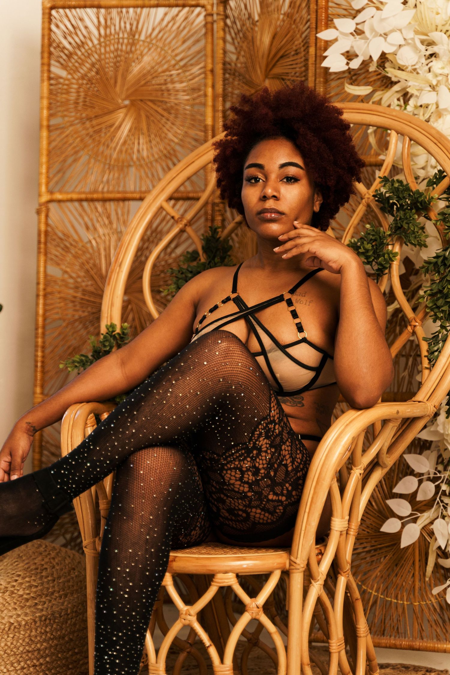 Glamour photography session with wicker furniture and golden decorative backdrop.