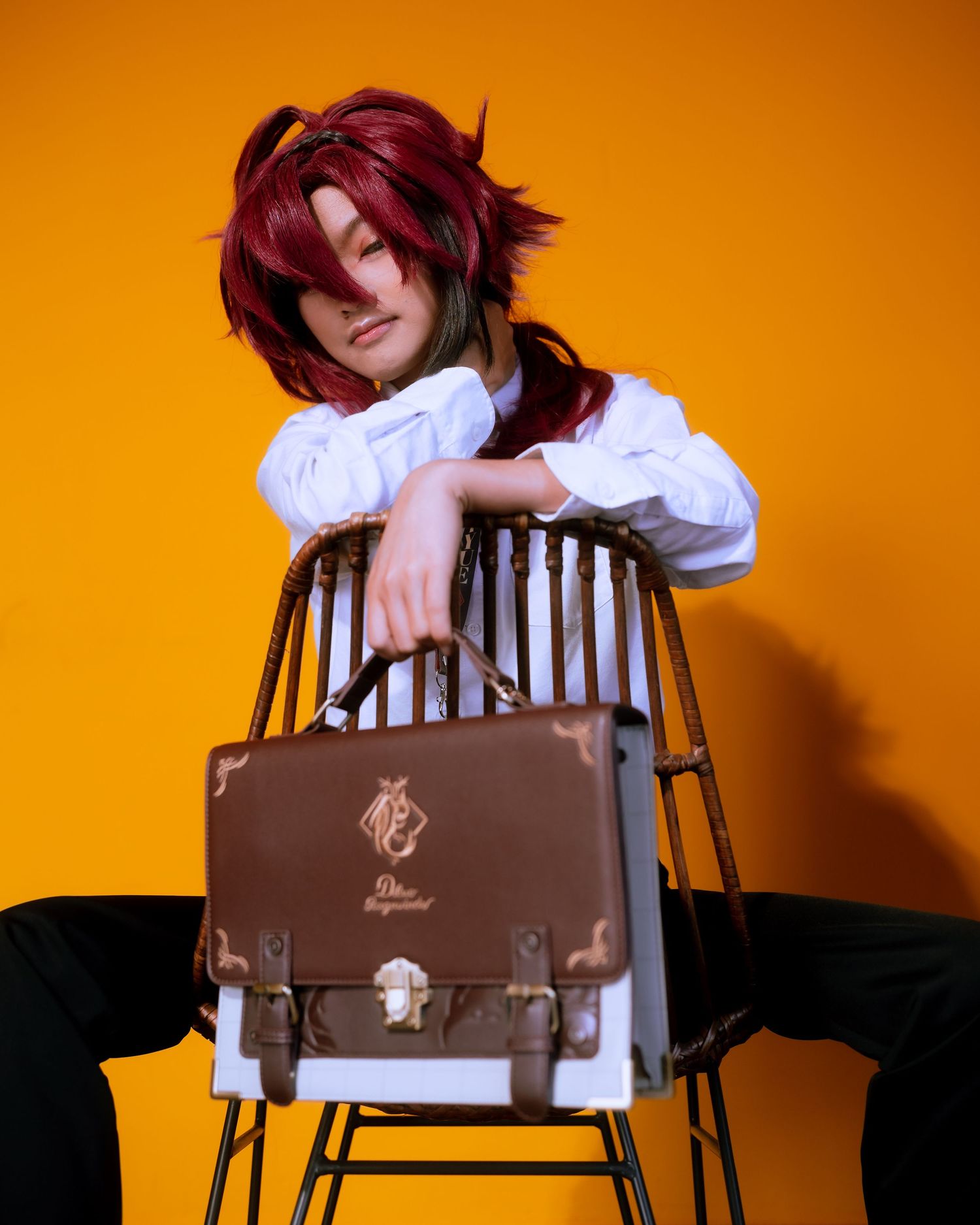Artistic portrait series against bright orange background with vintage school chair.