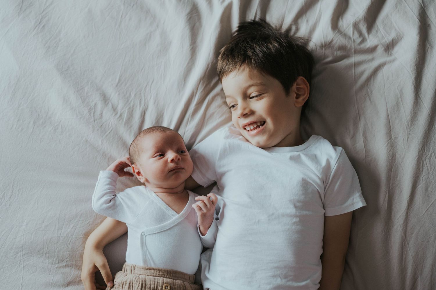 photographe famille Cholet séance photo nouveau né à domicile. Naturelle, lumière douce elle représente une fratrie de garcons (des frères)