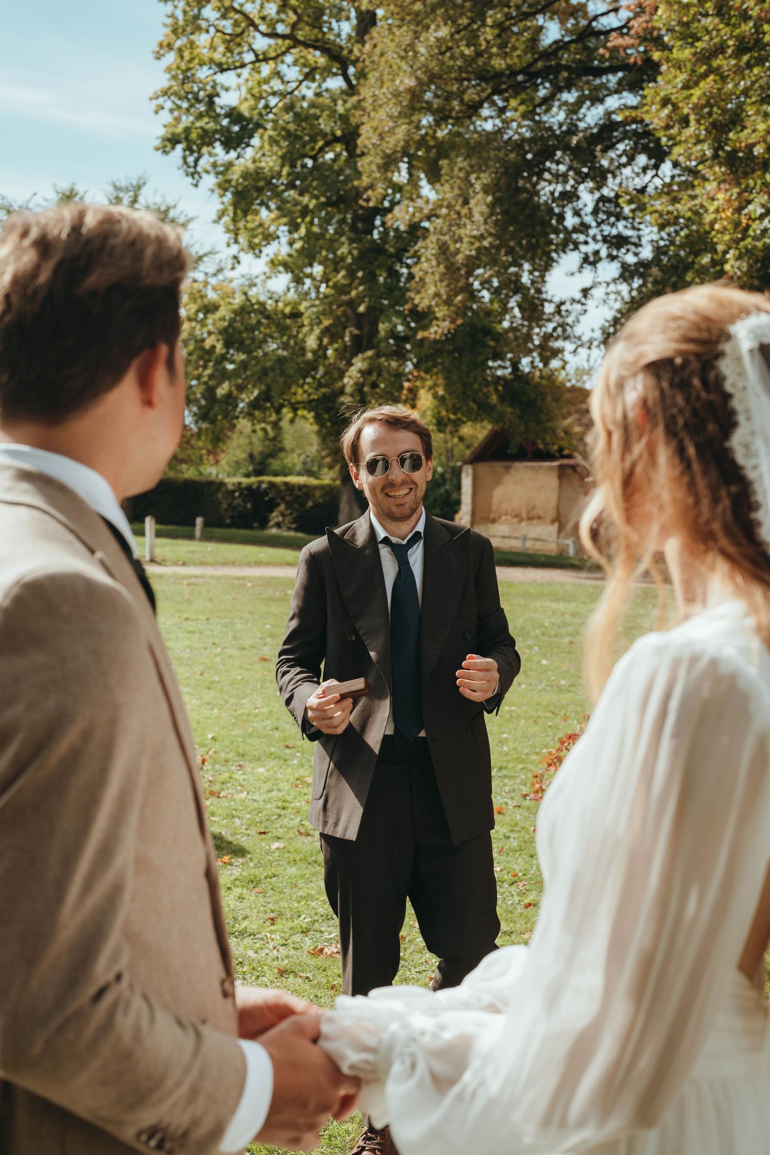 photographe mariage Maine-et-Loire cérémonie laique, un homme apporte les alliances aux mariés, souriant. 
 haras de la potardiere