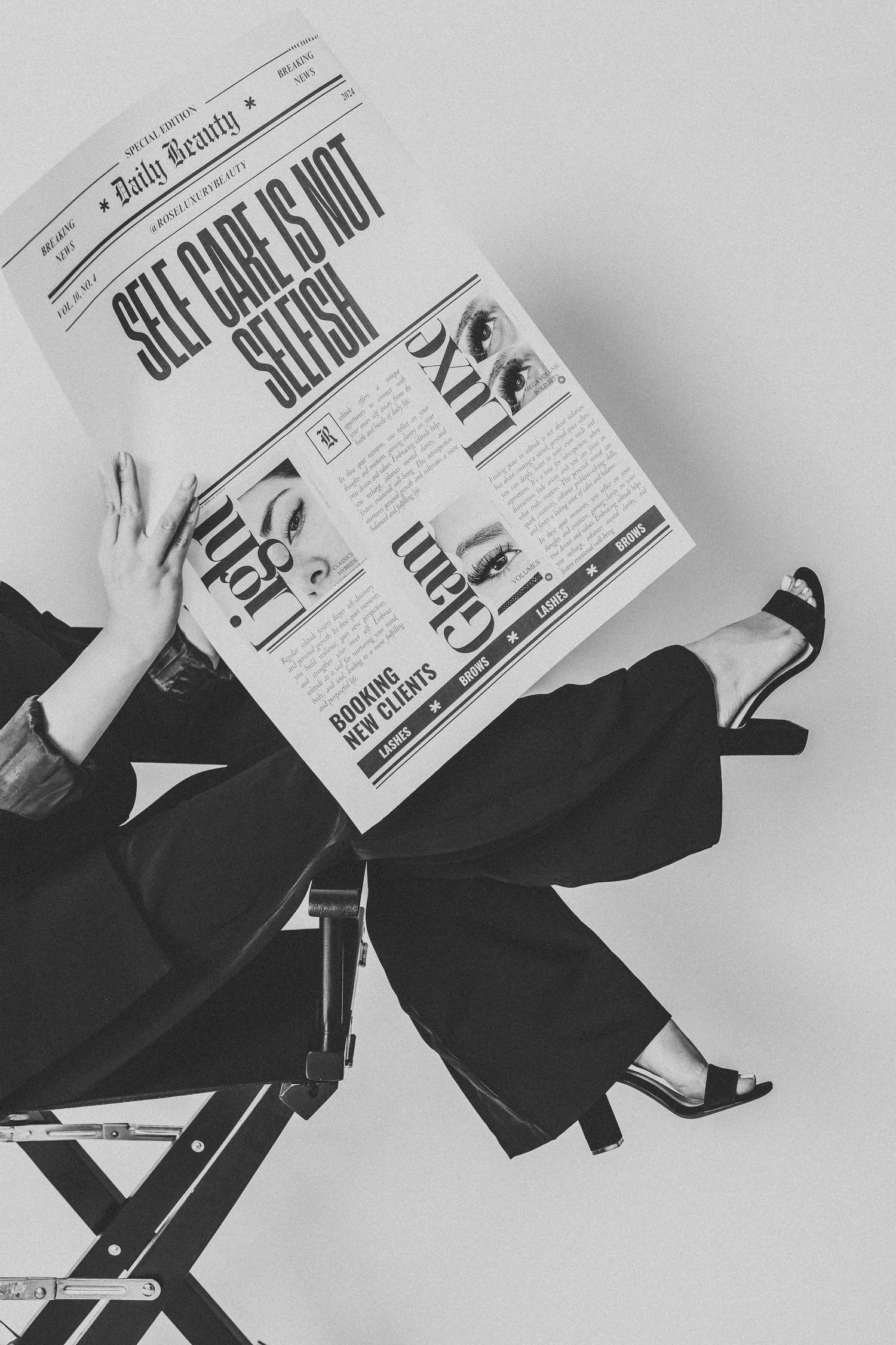 Artistic black and white photo of someone reading a newspaper in professional attire.