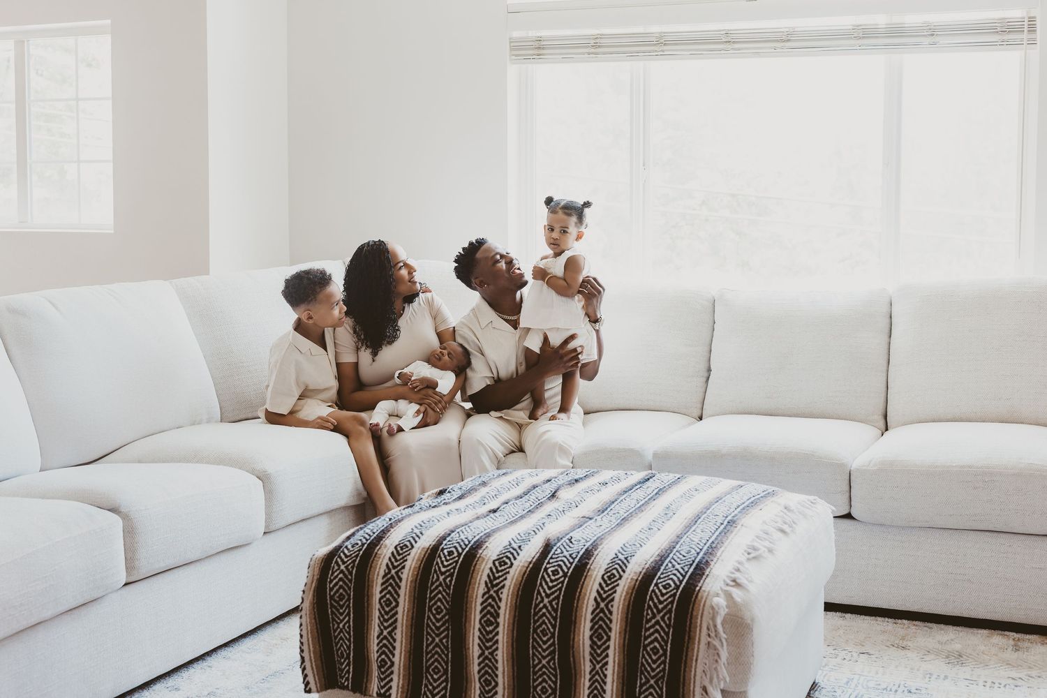 Children sitting and playing on white sectional sofa.