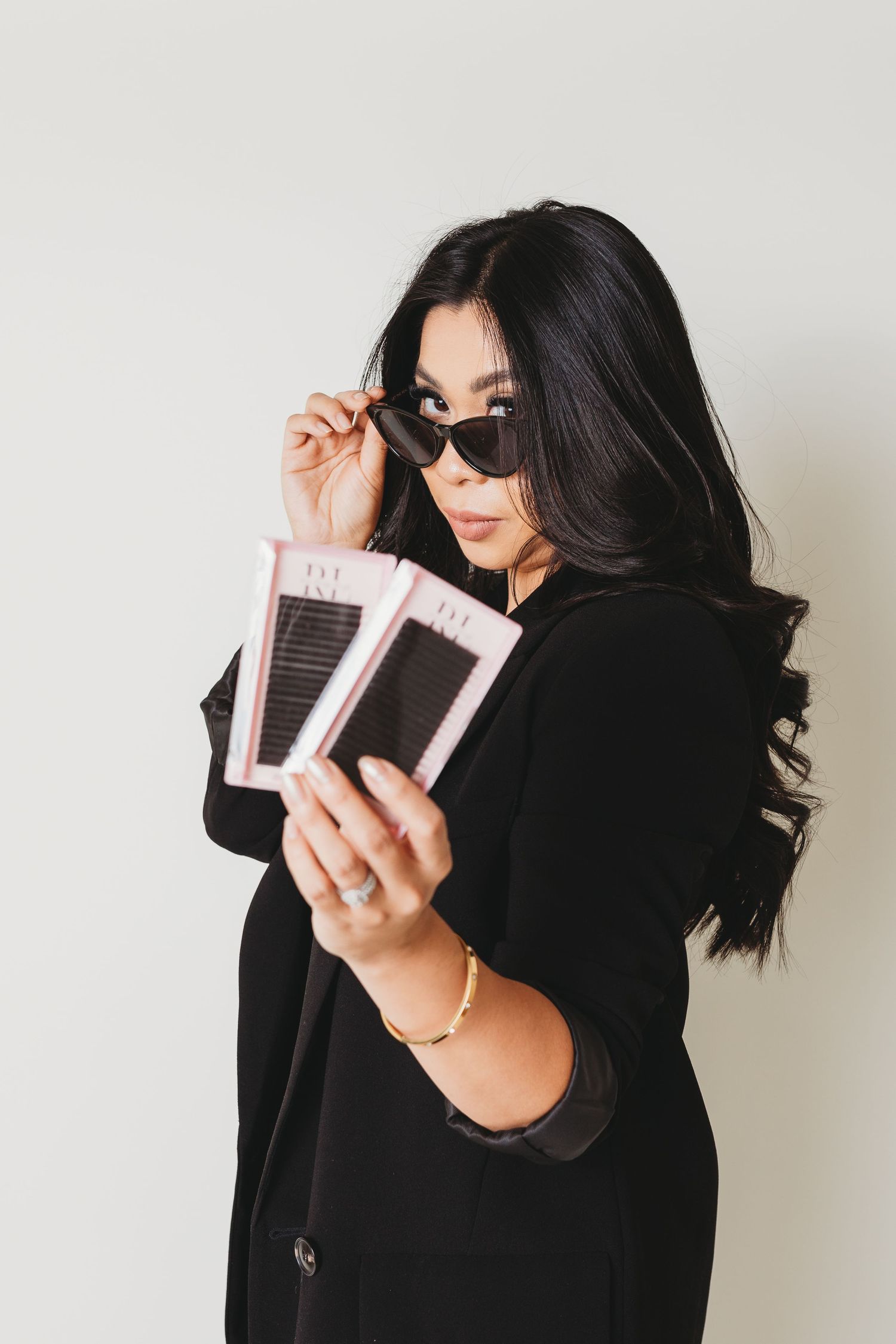 Fashion editorial featuring sunglasses and product displays in black attire.