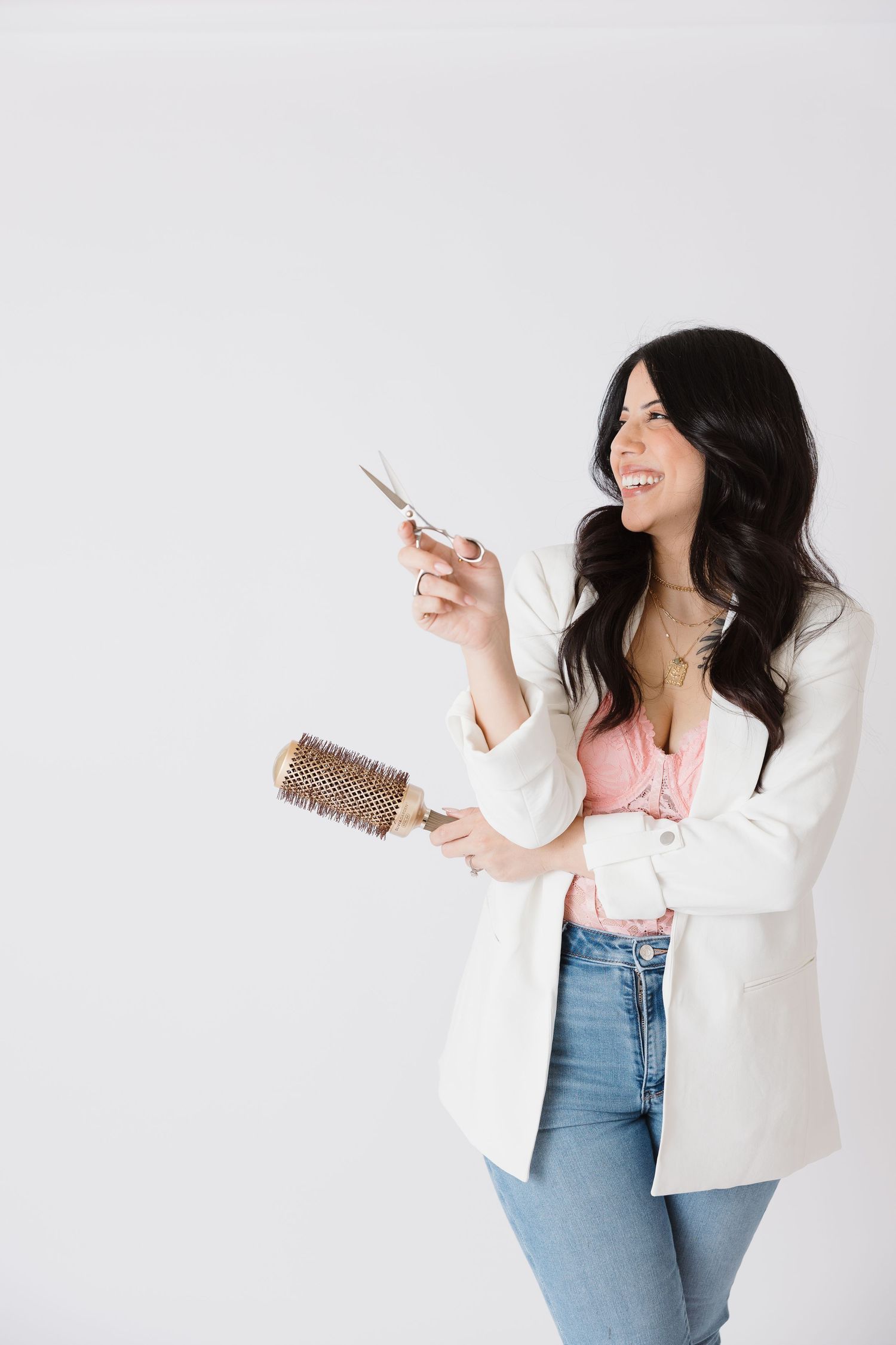 Woman in white blazer and jeans posing against white background with animated expressions.