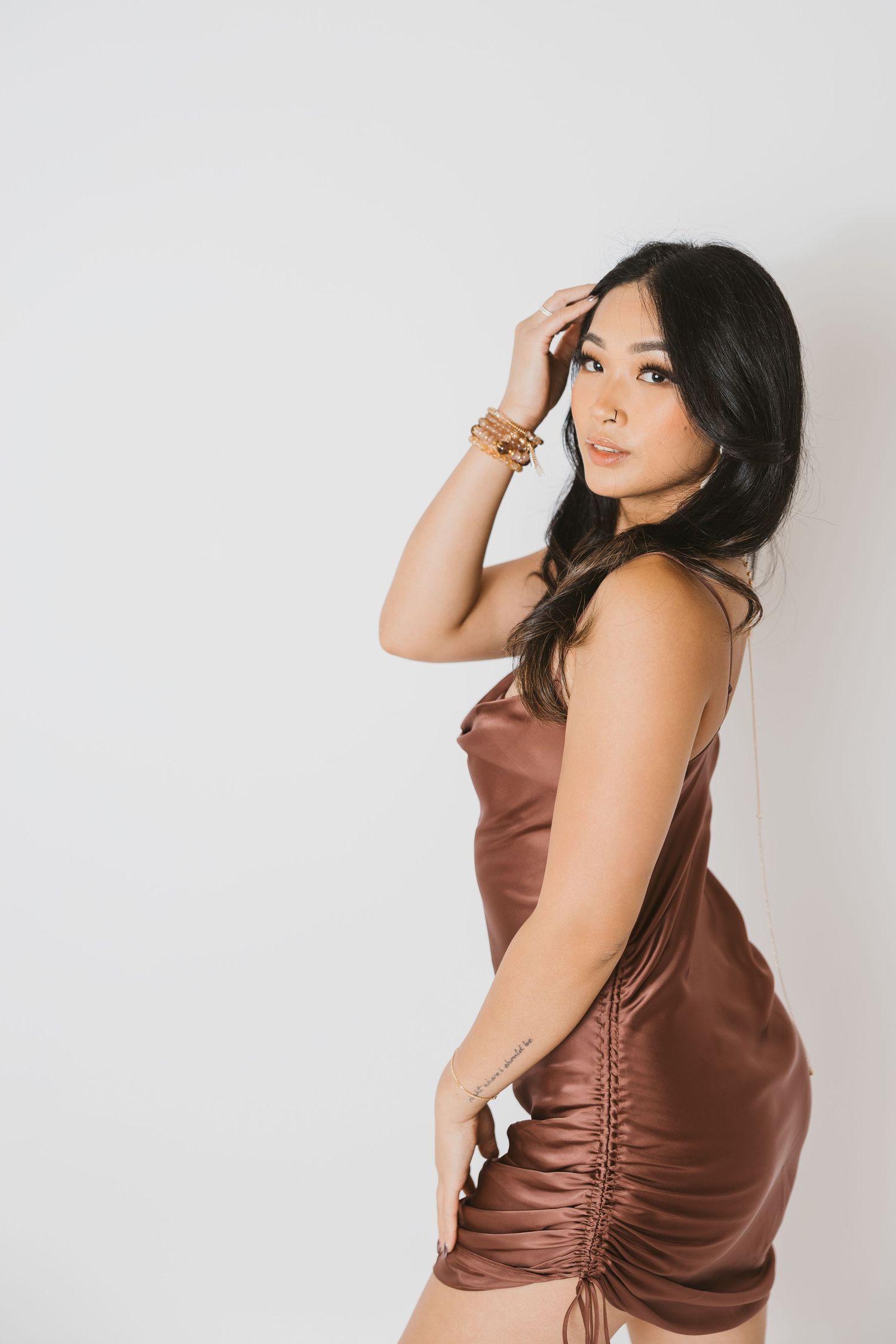 Fashion portraits in satin brown dress against white studio background.