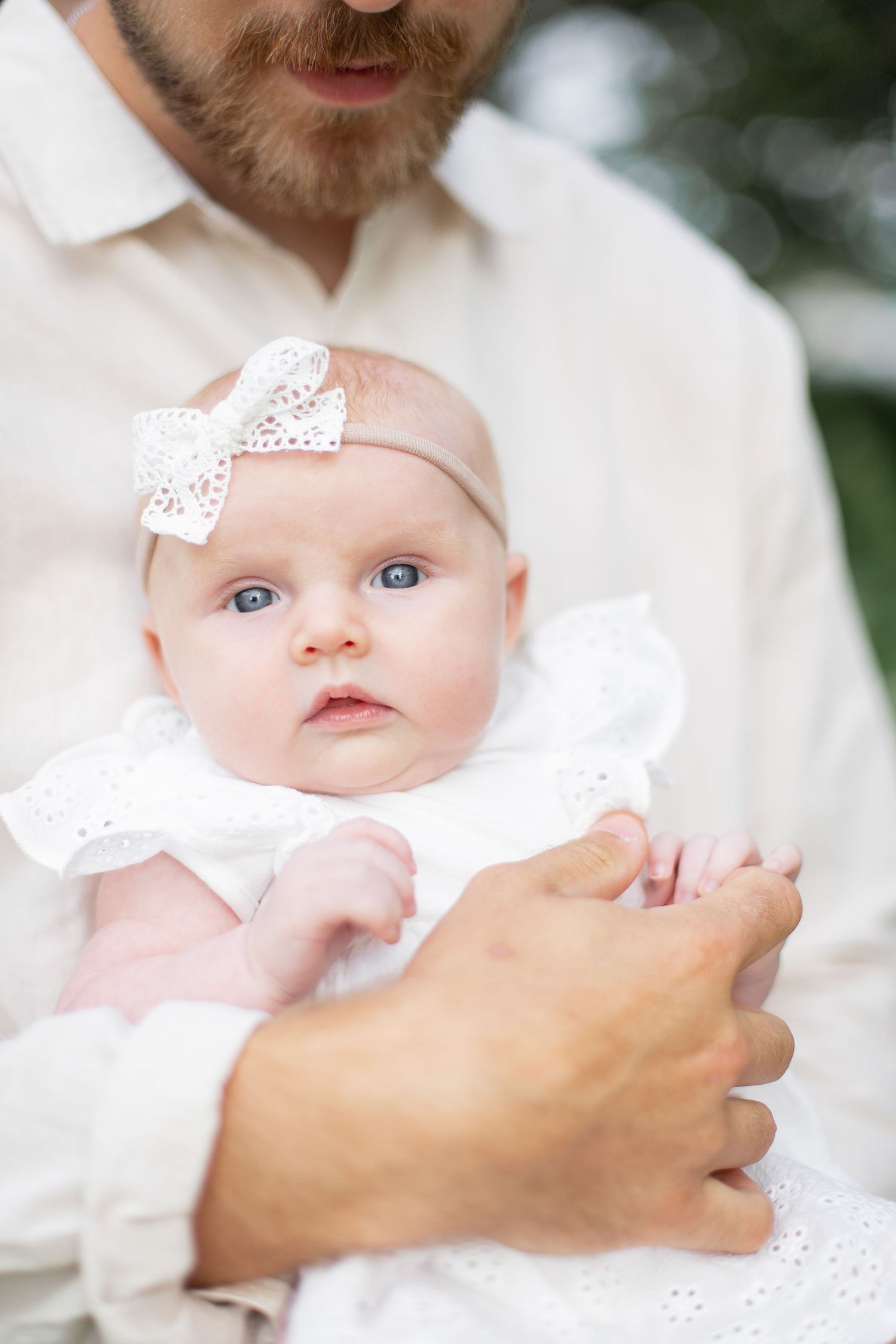 Nyfödd bebis i pappas famn under en familjefotografering.