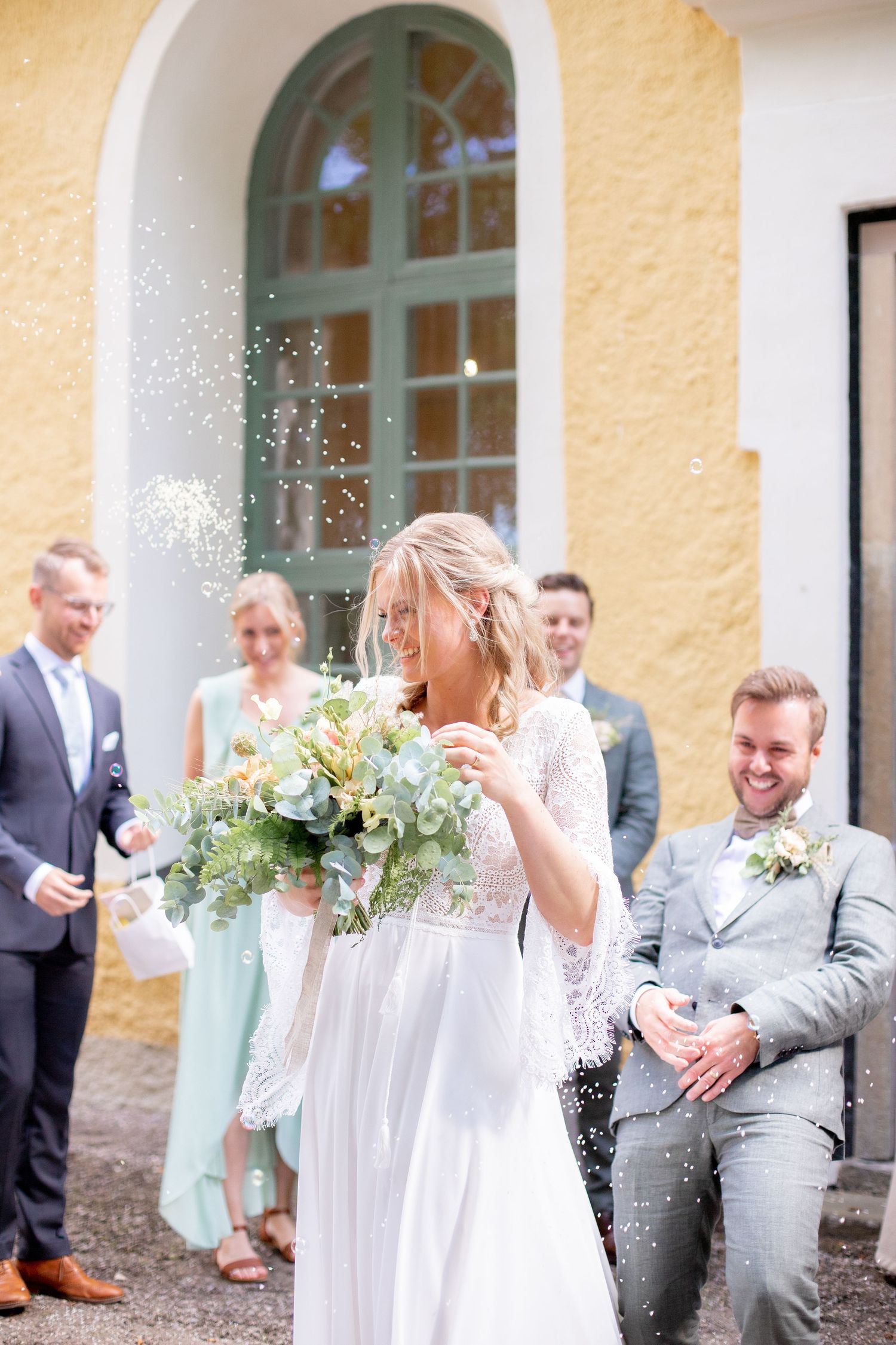 Brudparet under riskastning efter vigseln. Österåkers kyrka. Bröllopsfotografering. Jag är en bröllopsfotograf i Katrineholm.
