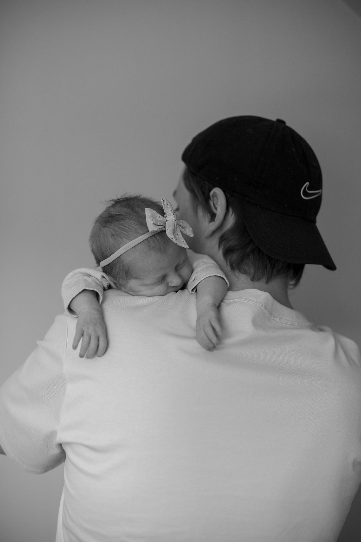 Familjefotografering i Katrineholm. Nyfödd ligger på pappas axel.