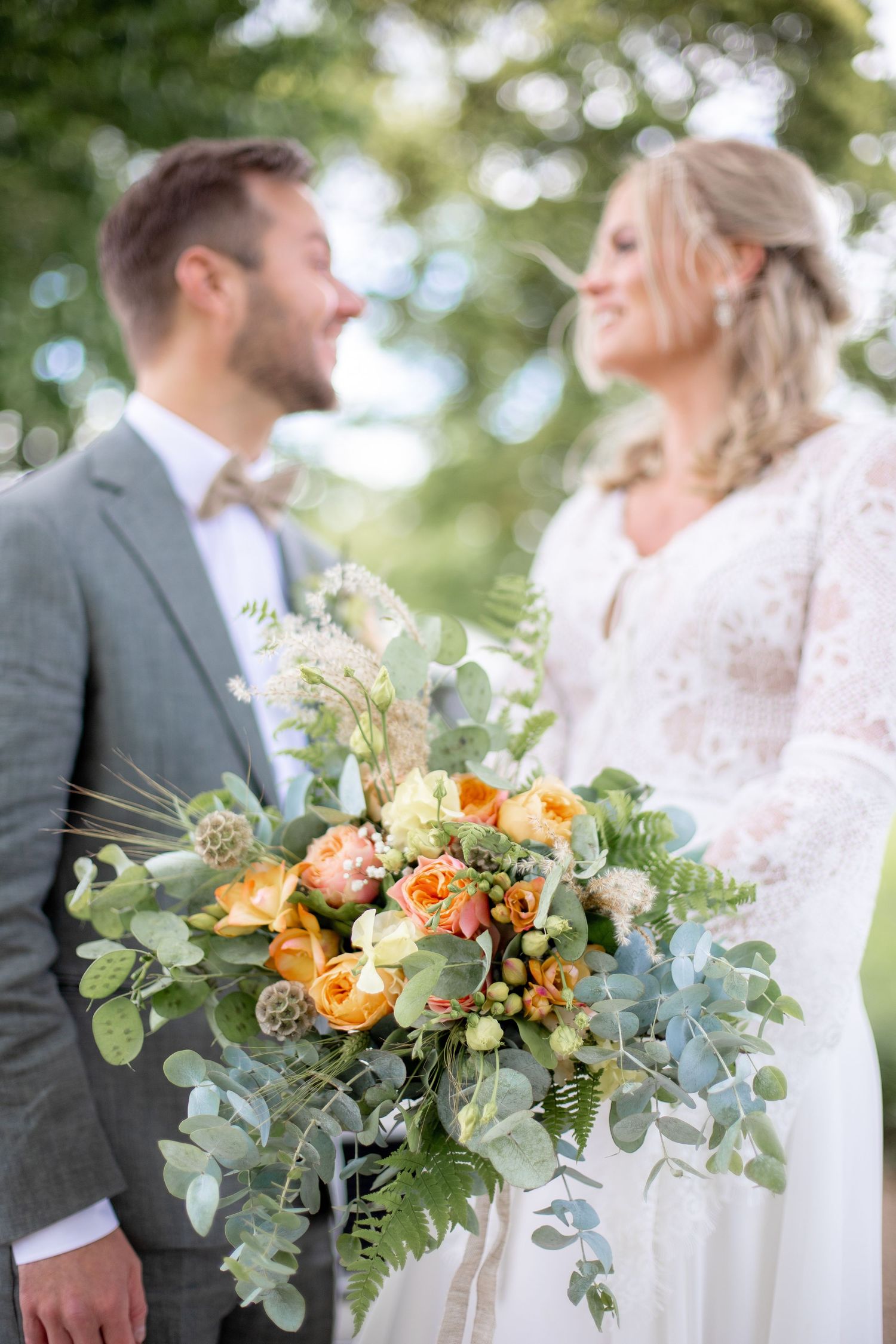 Brud och brudgum under bröllopsfotografering, fokus på den vackra brudbuketten.