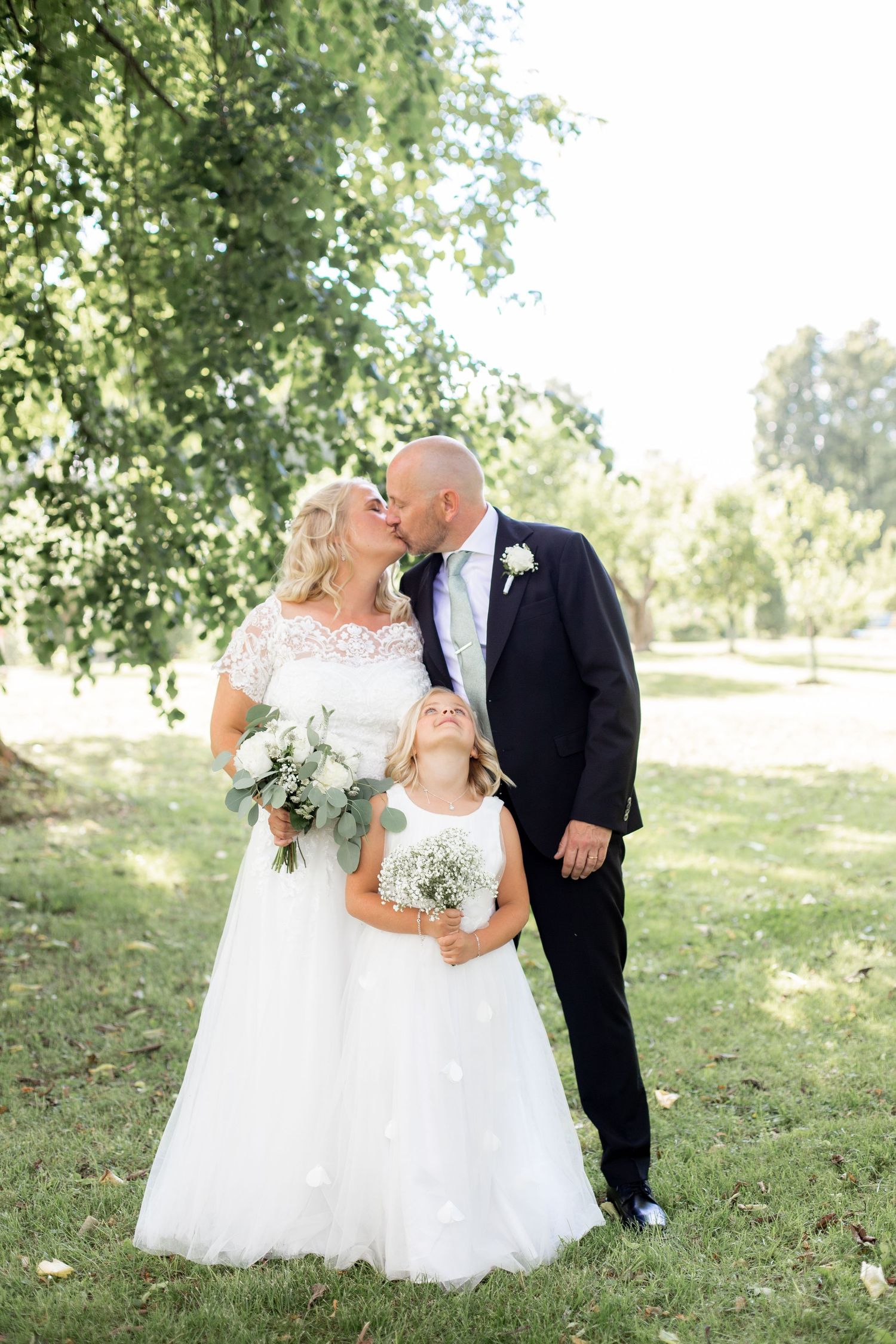 Brud och brudgum i en kyss under ett vackert träd. Bröllopsfotograferin på Djulö herrgård i Katrineholm.
