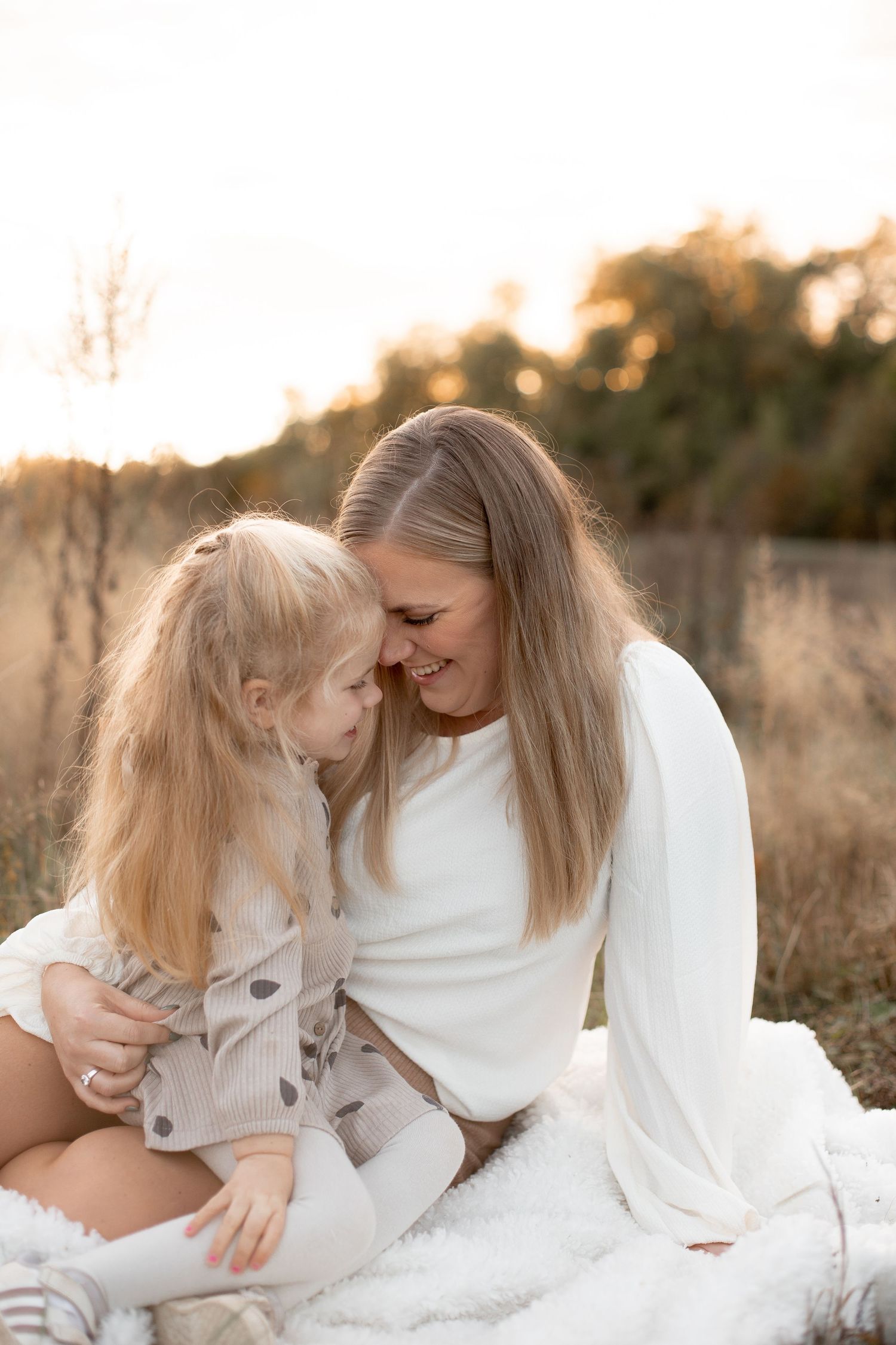 Mamma och dotter kramas och skrattar under en familjefotografering i Katrineholm.