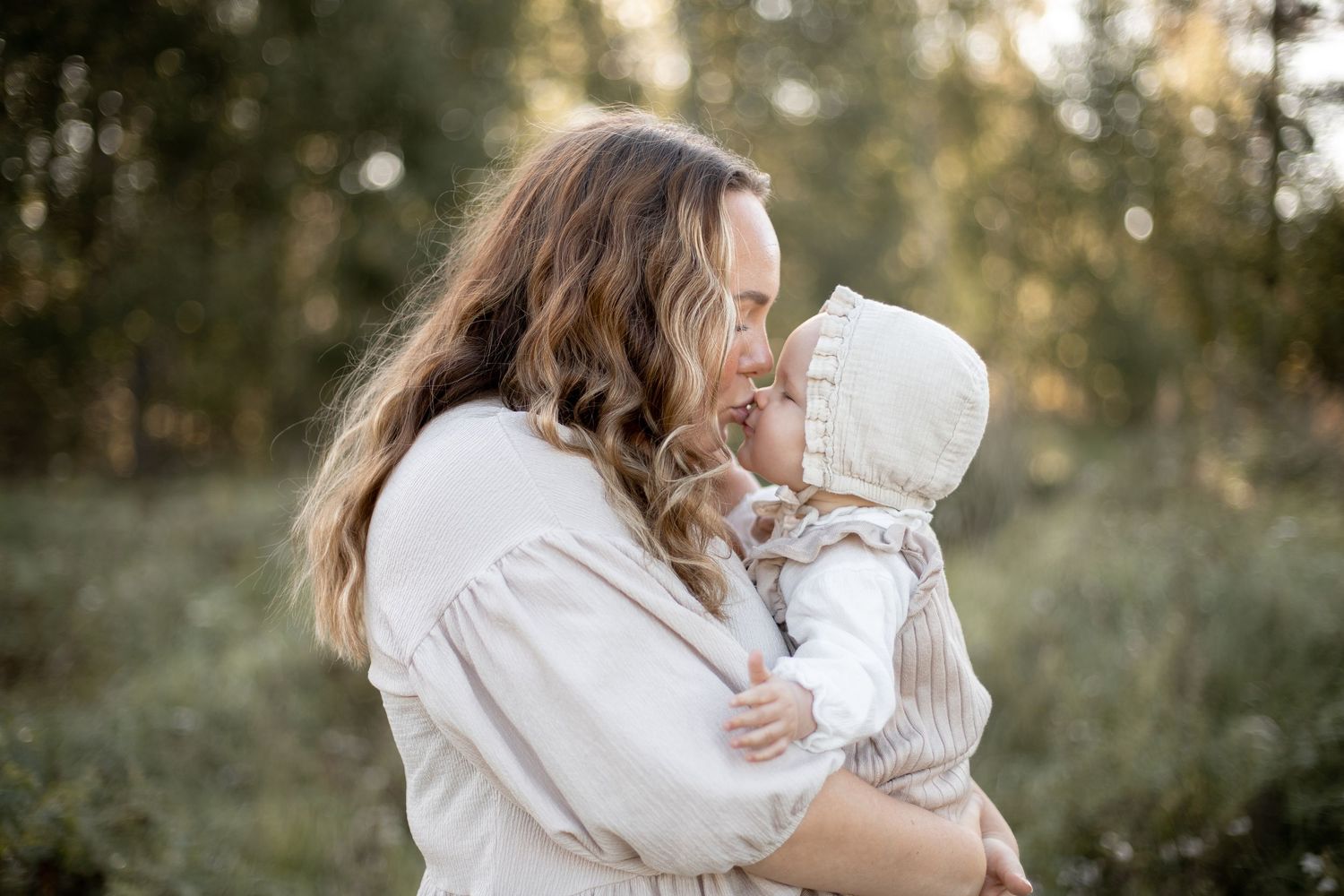 Mamma och 1årig dotter pussas under familjefotografering i Katrineholm.