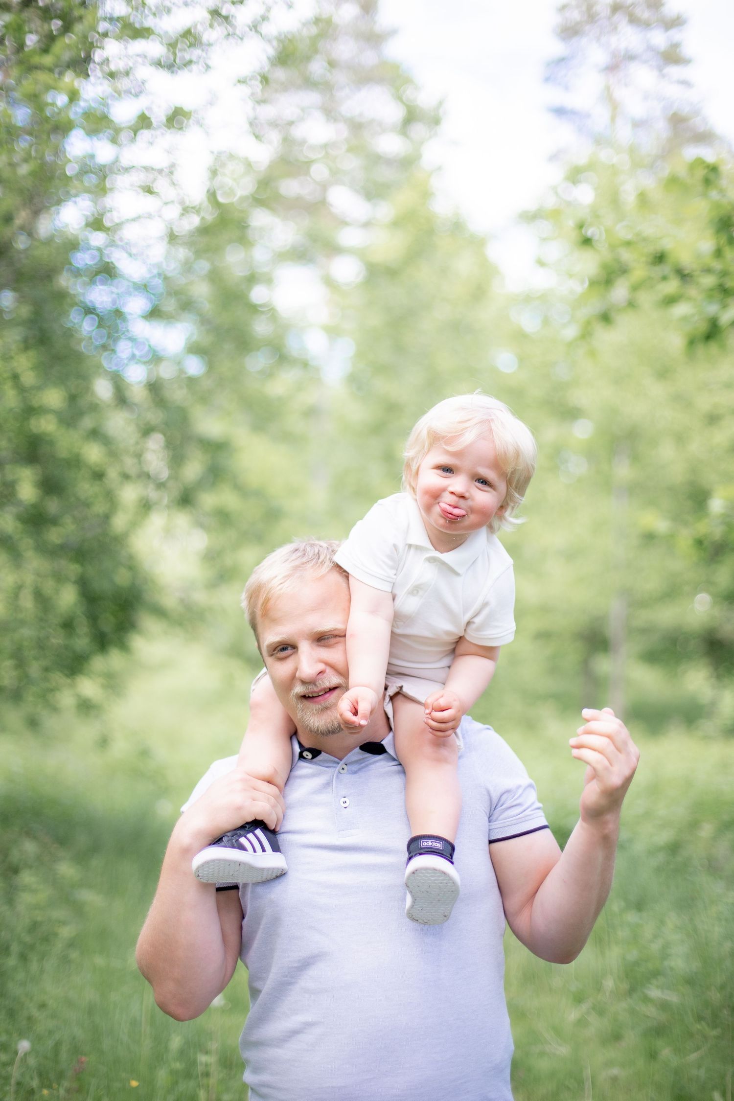 Barn sitter på pappas axlar och busar. Familjefotografering i Katrineholm.