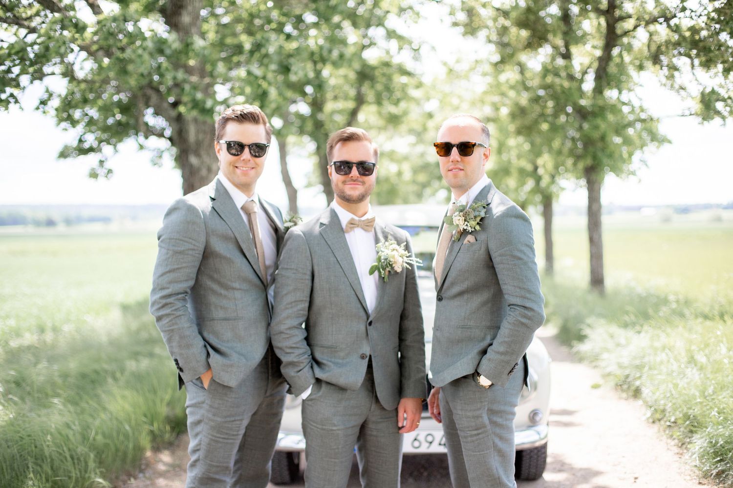 Brudgum och hans bestman i solglasögon under en bröllopsfotografering.