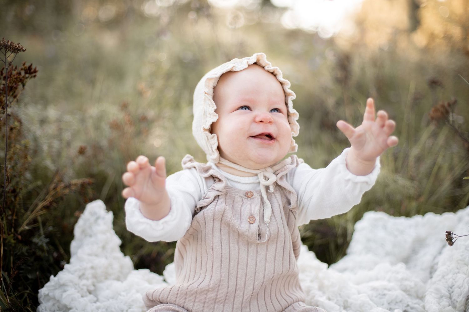 Glad bebis sträcker ut armarna. Familjefotograf i Katrineholm.