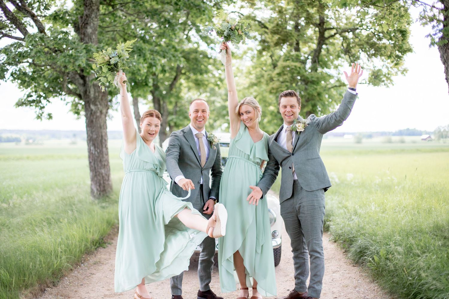 Brudfölje hoppar glada under bröllopsfotografering.
