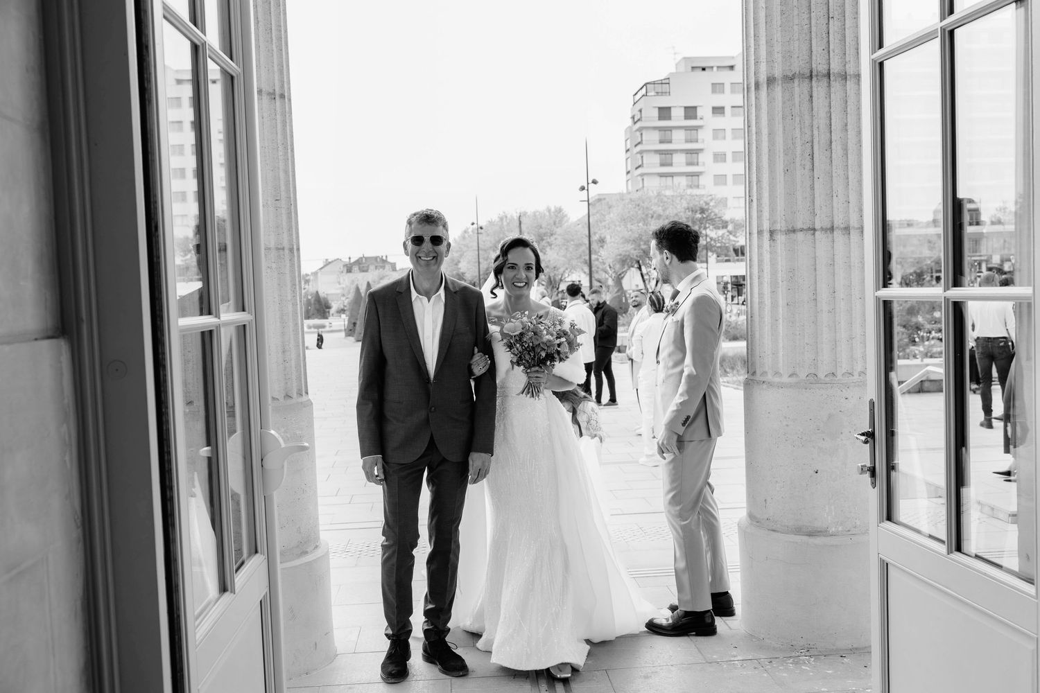 Photo en noir et blanc de la suite nuptiale marchant à la mairie de Angers.