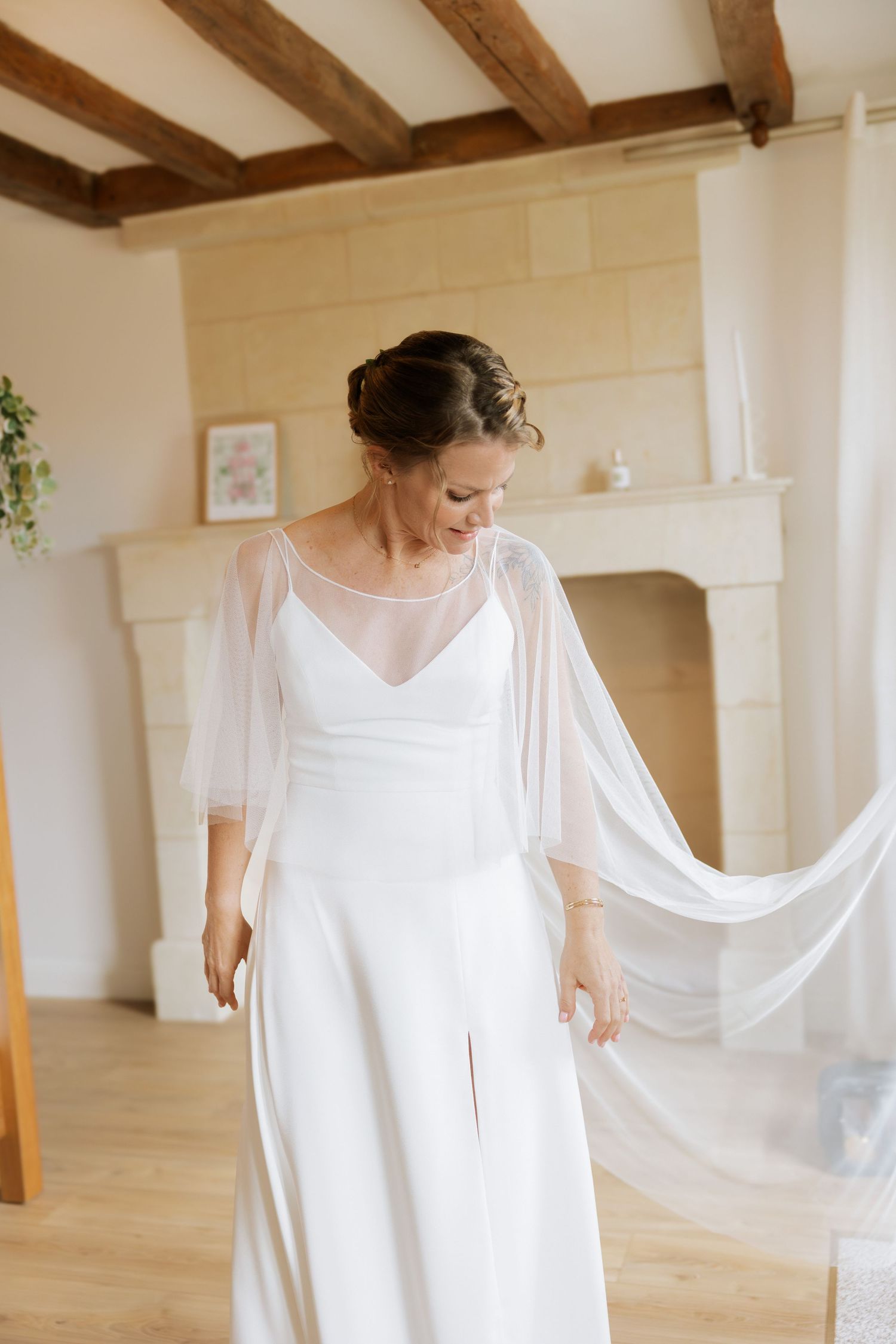 Flowing white dress captured in motion against white walls with wooden beams.