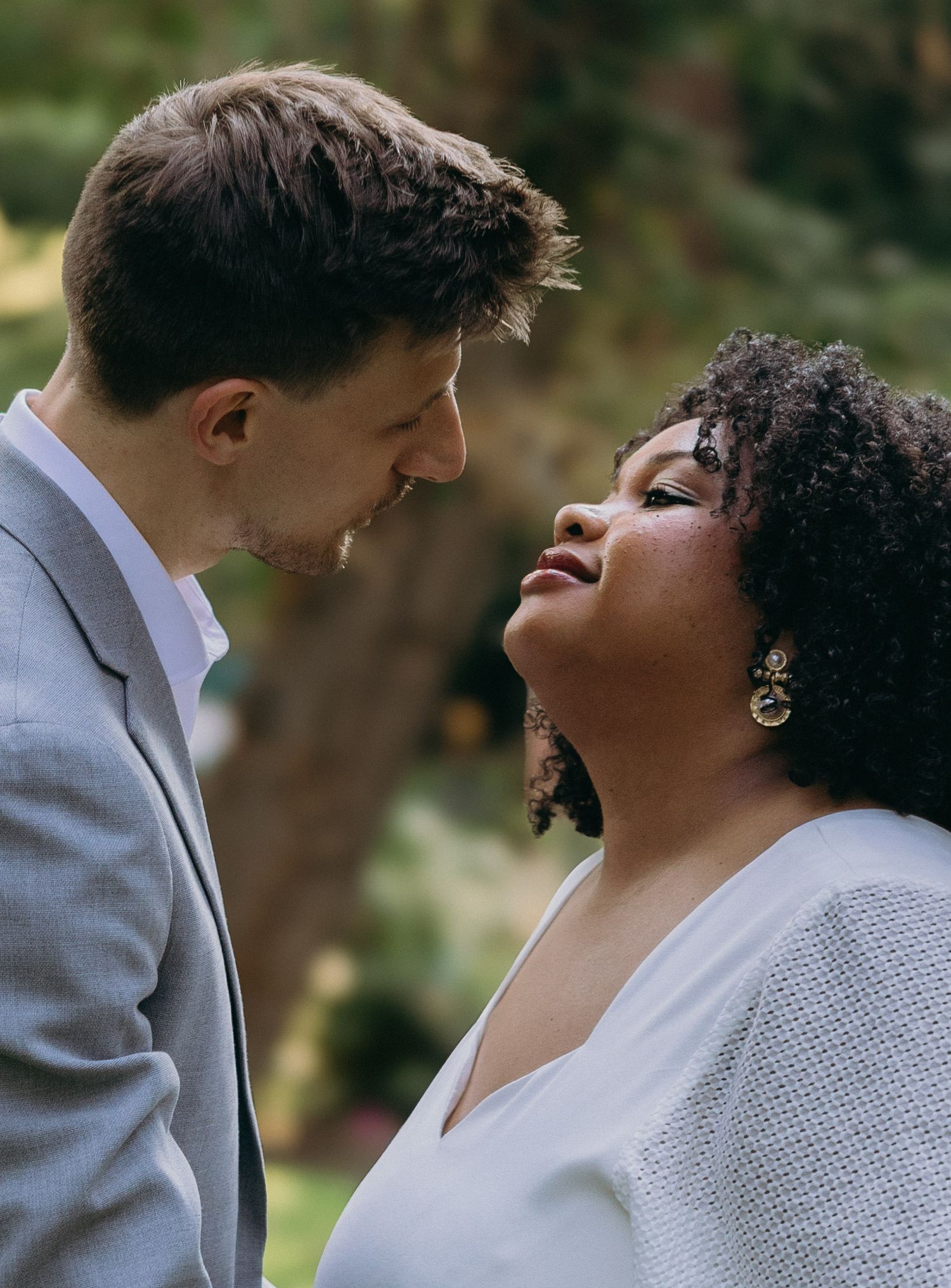 A couple shares laughter and intimate moments in a natural outdoor setting.