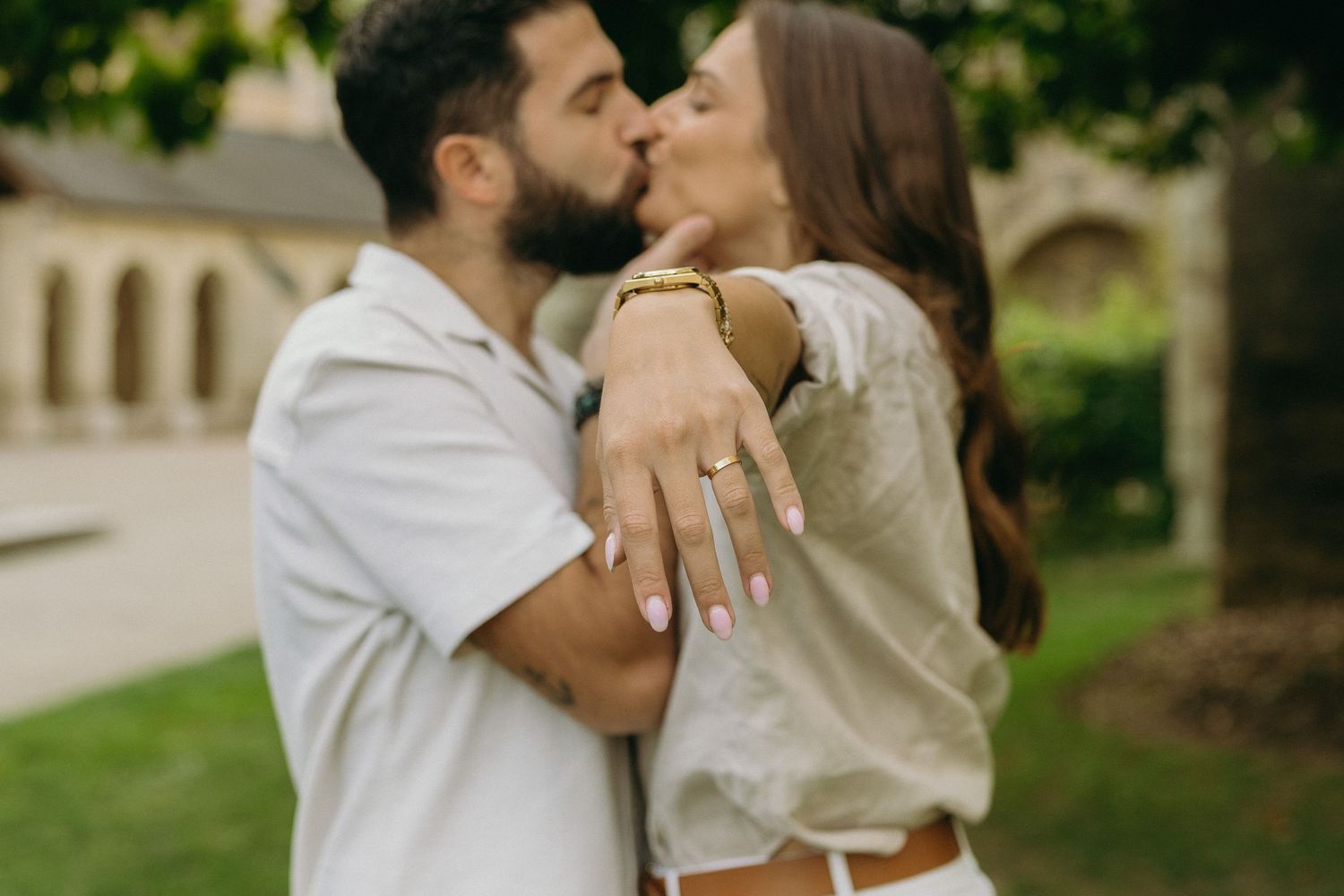 An intimate moment showing an engagement ring prominently displayed during a romantic kiss.
