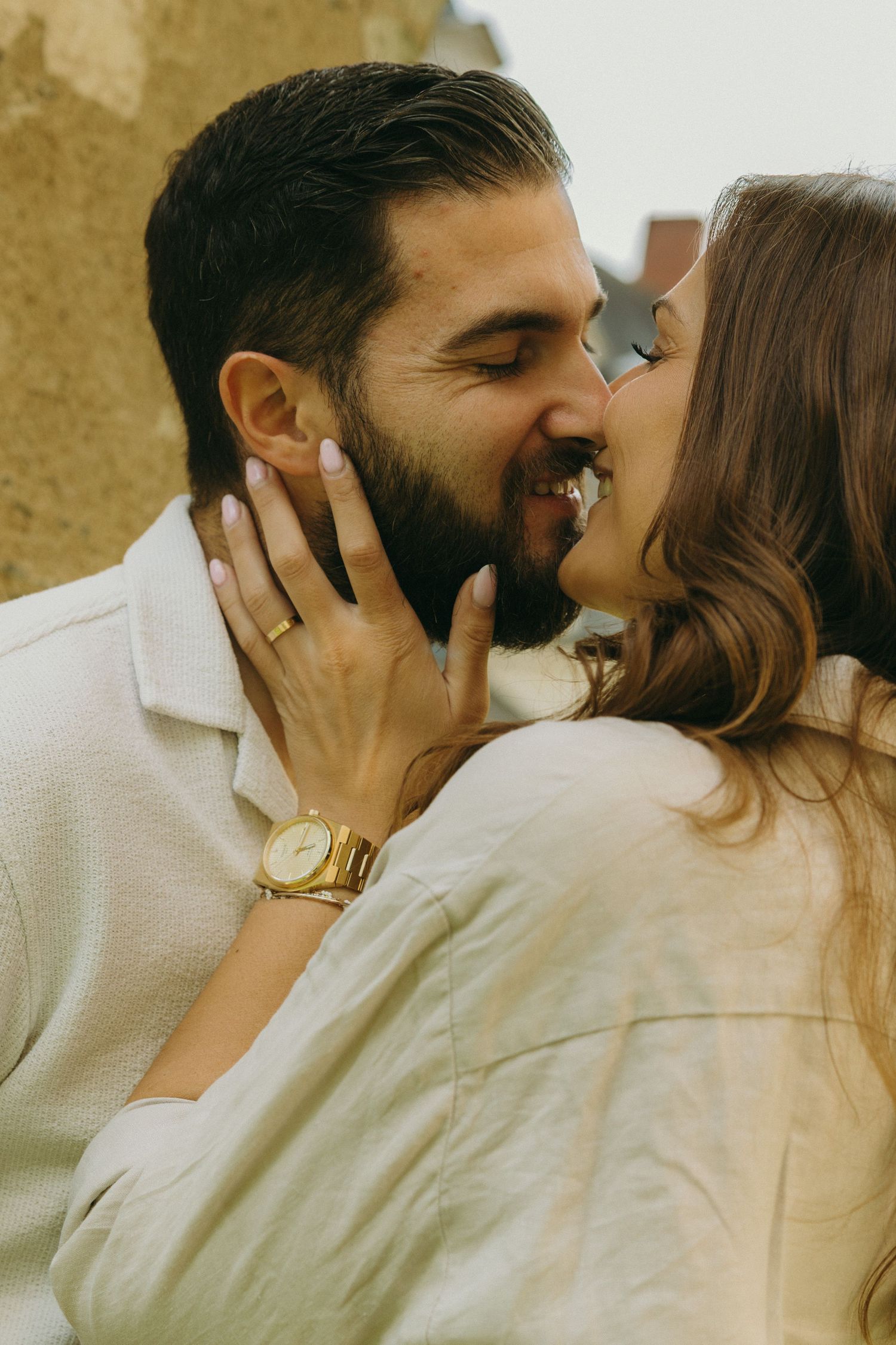 A close-up romantic moment between a couple wearing matching white outfits.