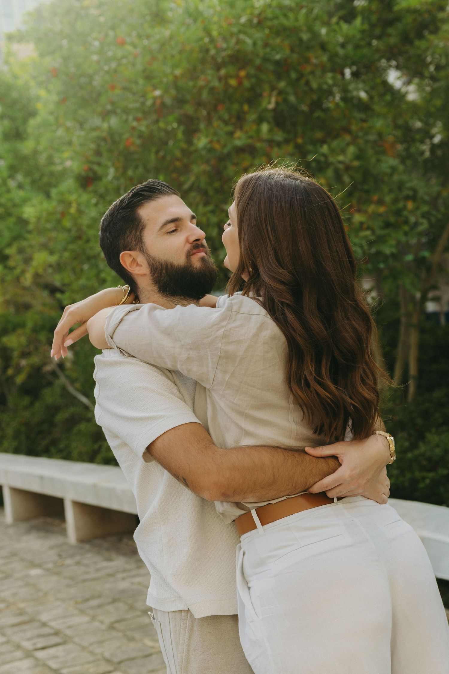 Romantic sequence of couple in white outfits embracing outdoors.