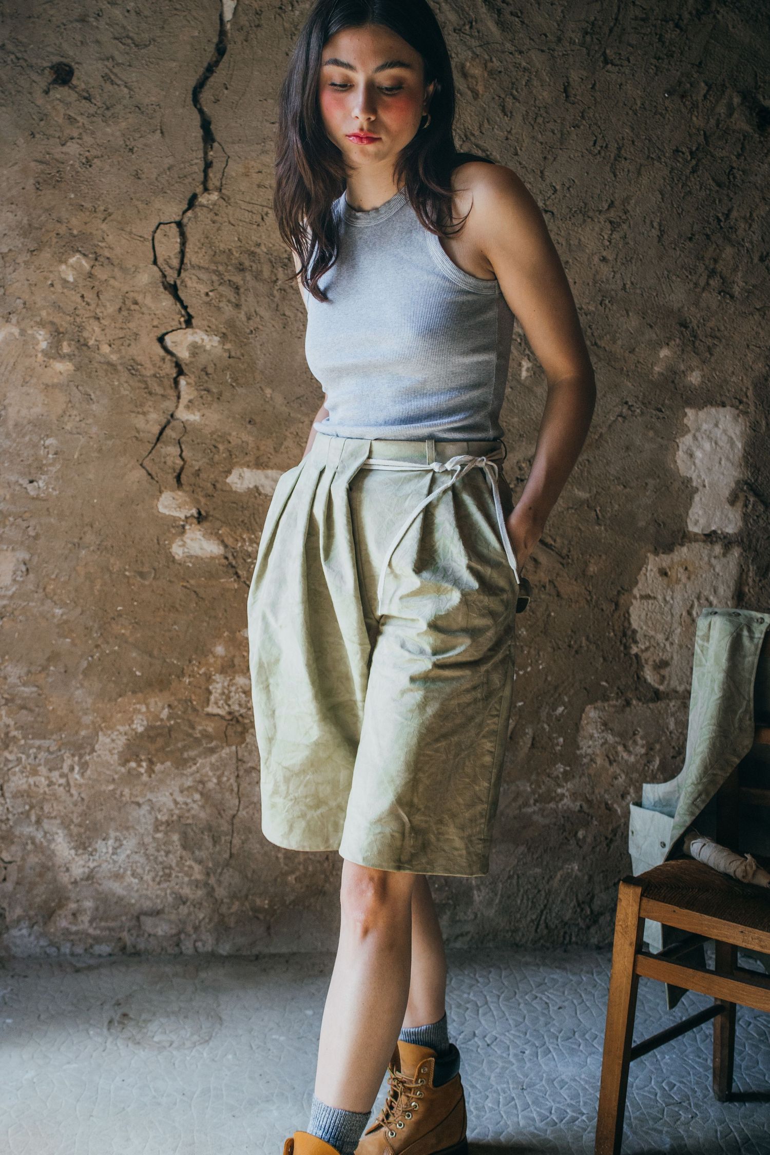 Fashion shot featuring a gray tank top and high-waisted khaki shorts with boots.