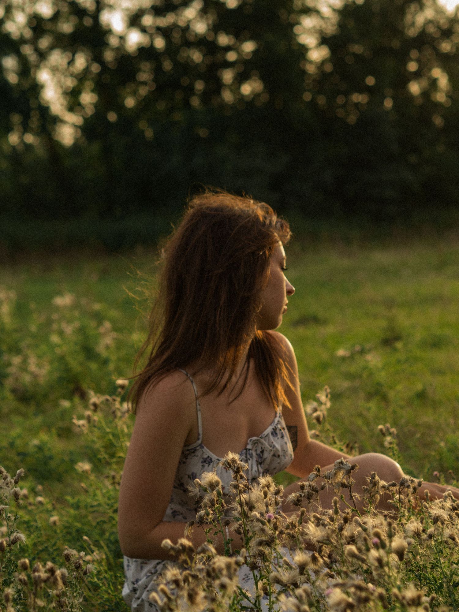Dreamy sunset portraits in a field with wildflowers and natural golden hour lighting.
