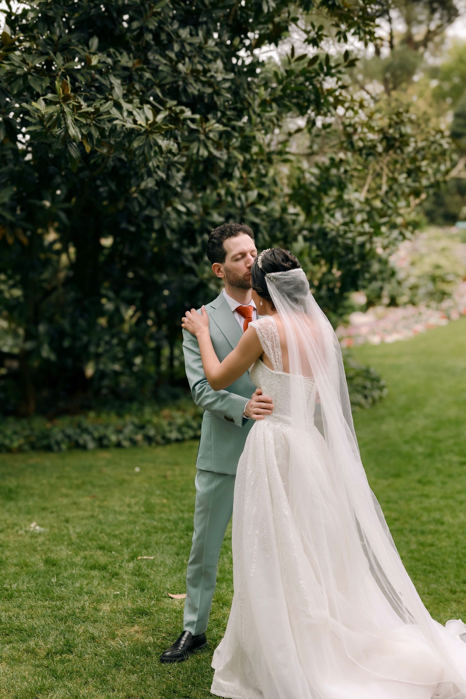 Couple lors de leur first look dans un jardin à angers, voile de la mariée au vent