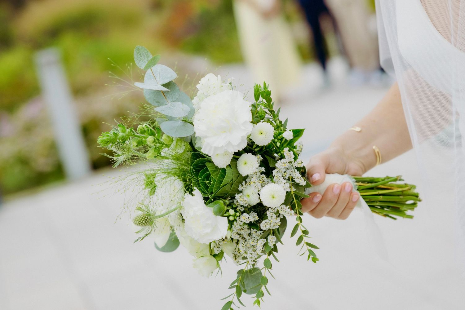 Elegant white and green wedding bouquet with eucalyptus leaves and delicate florals.