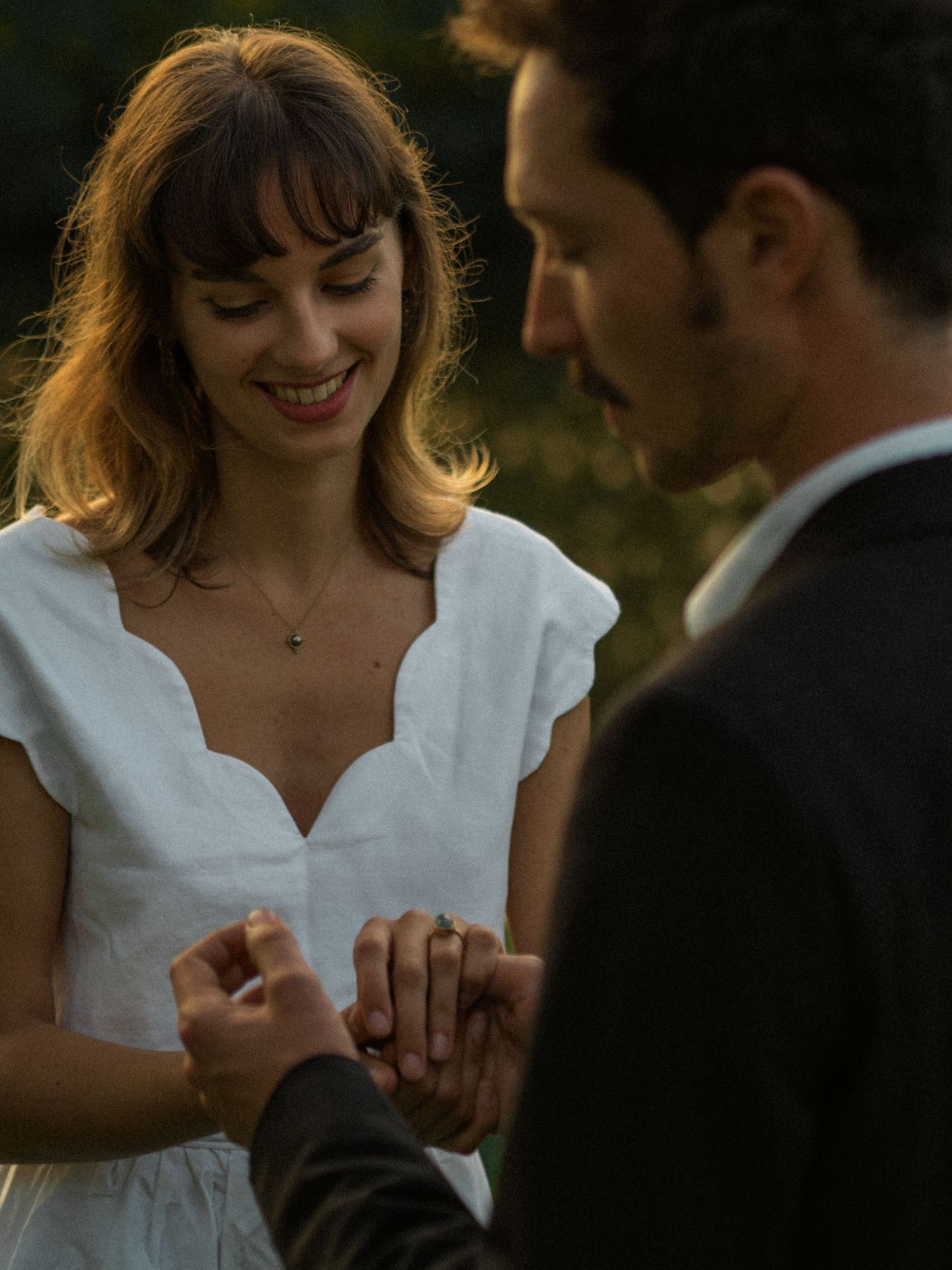 Un moment intime entre un couple en tenue de mariage lors d’une séance photo en extérieur.