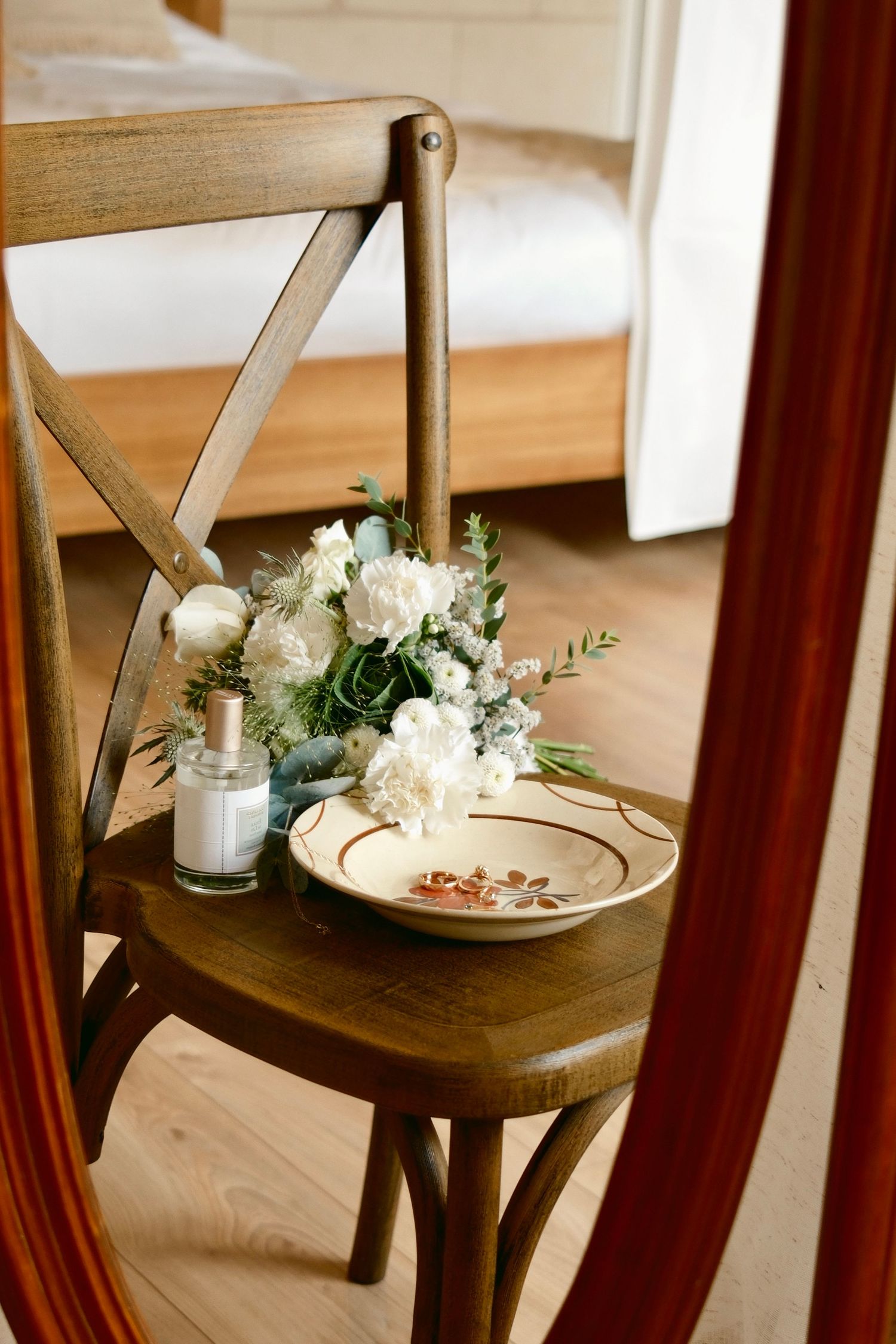 Wooden chair decorated with delicate white flowers and candles for a romantic setting.