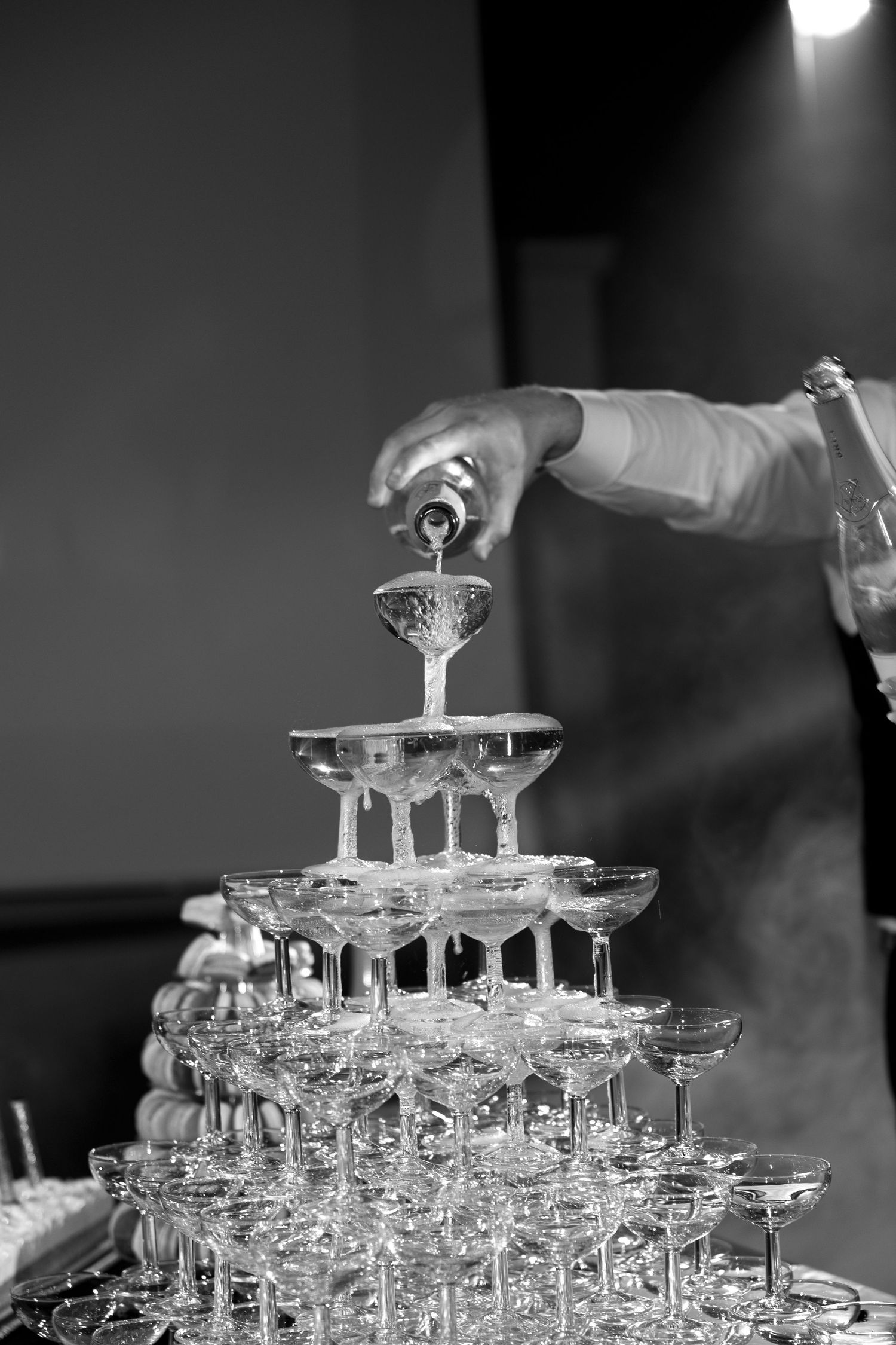 Photographie mettant en scène du champagne coulant dans une pyramide de verres en cristal, capturant l’élégance et la fête d’un événement