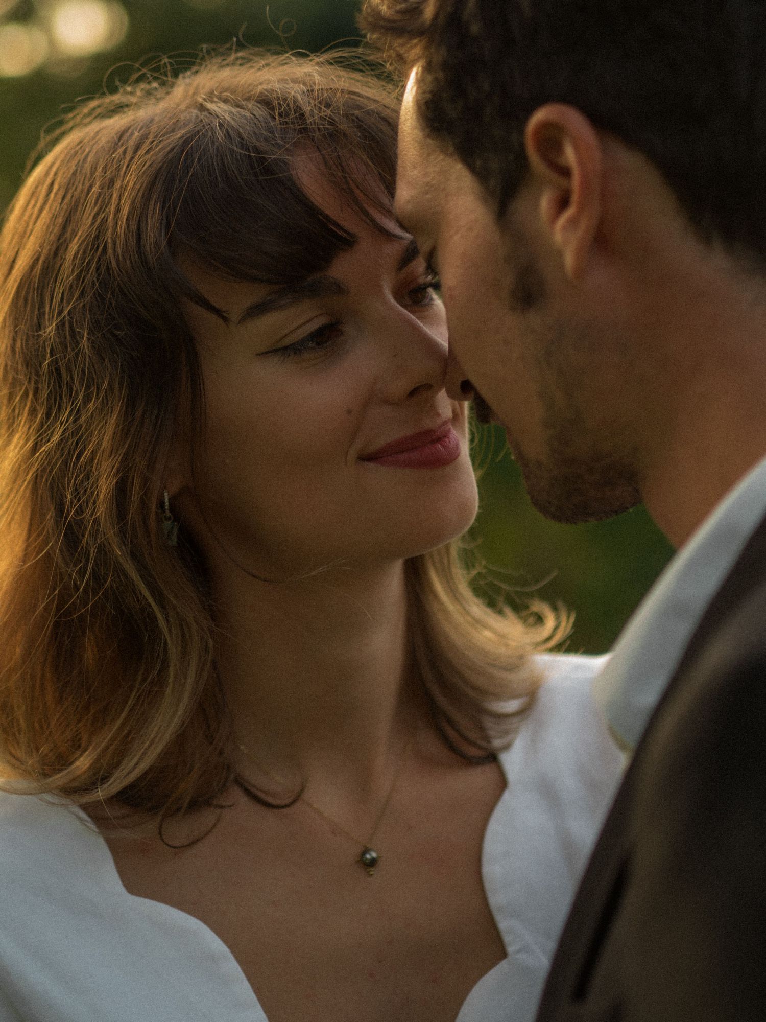 Couple en tenue de mariage partageant un moment romantique lors d’une séance photo au coucher du soleil à Angers