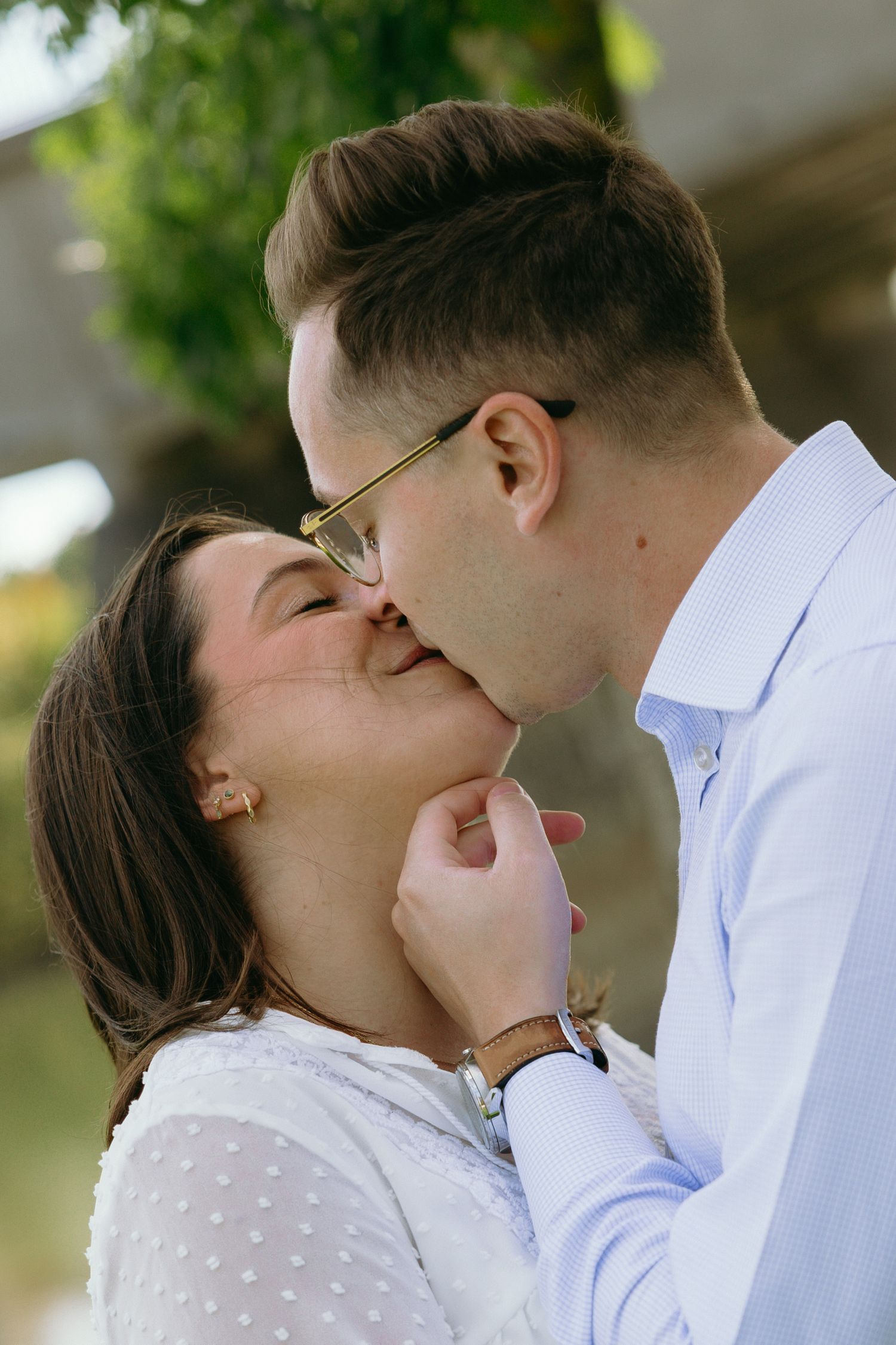 A romantic couple shares an intimate moment while wearing coordinated white outfits.