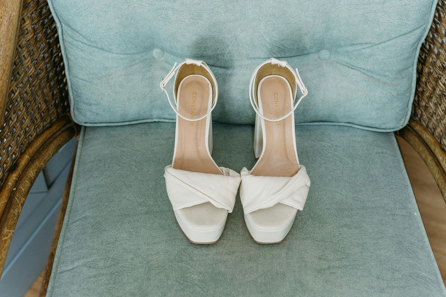 Chaussures de mariée blanches sur coussin en velours bleu clair, details préparatifs mariage