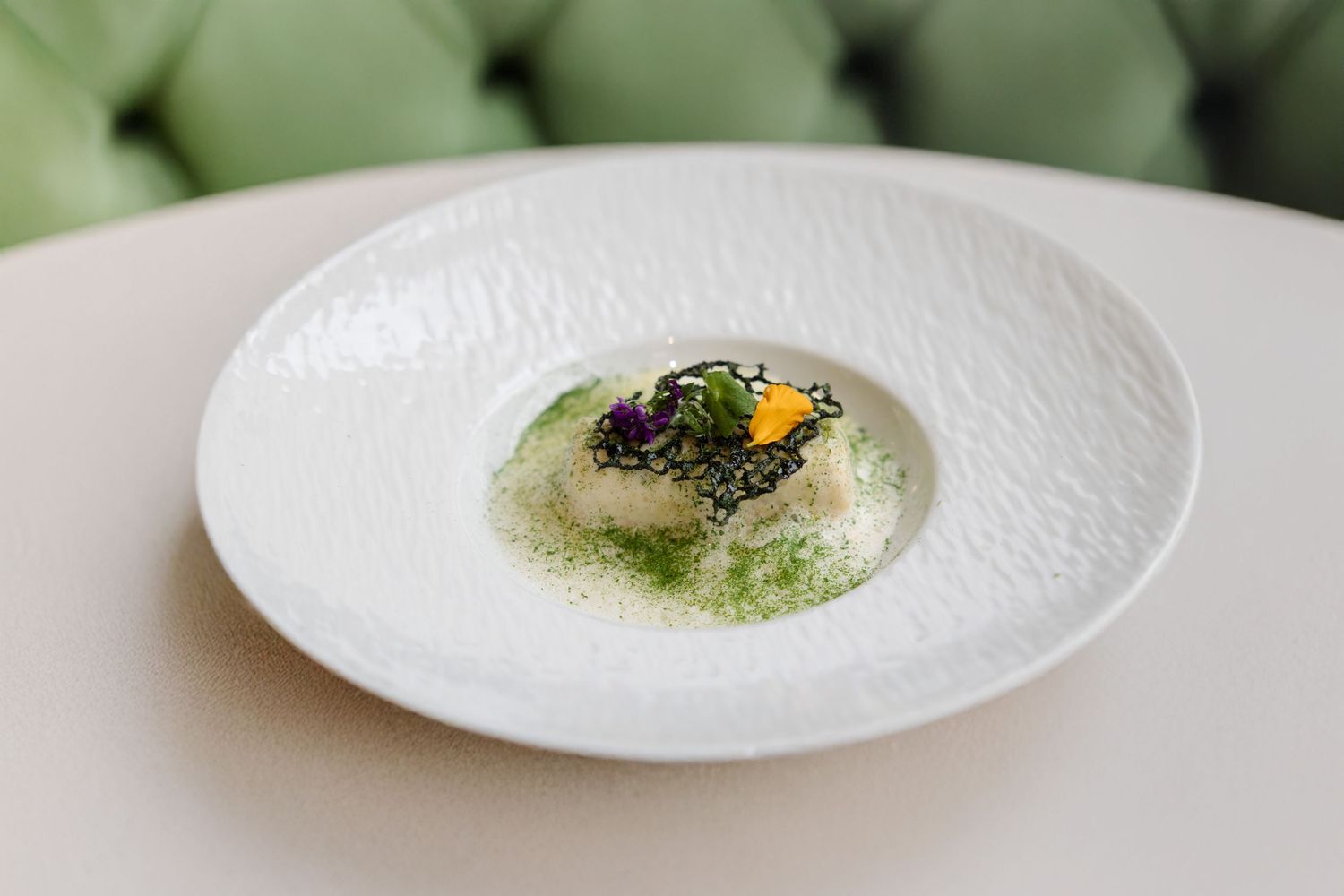 Sequence of elegant white plates with minimalist food presentation.
