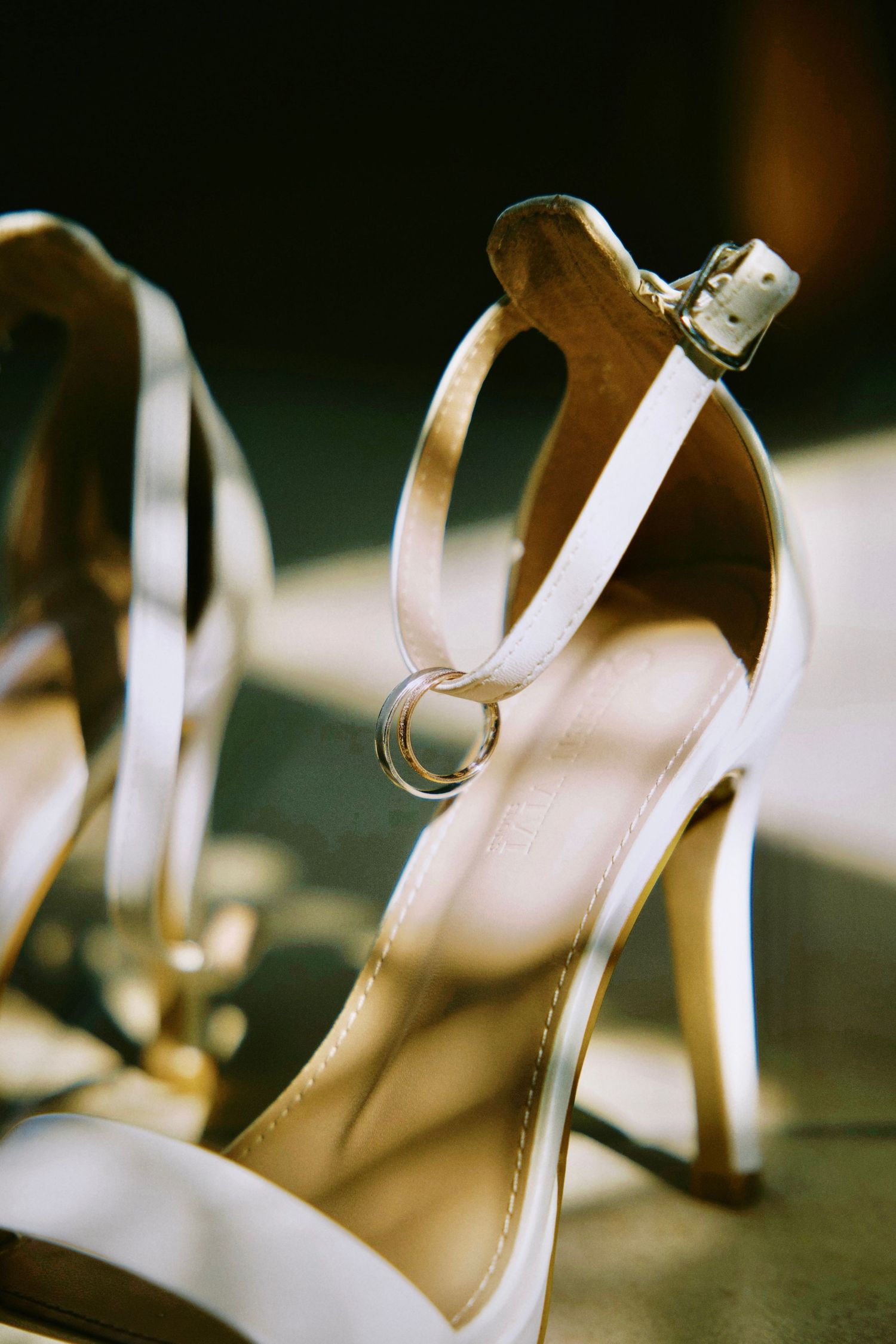 Delicate white wedding shoes displayed in a row with soft lighting and blurred background.