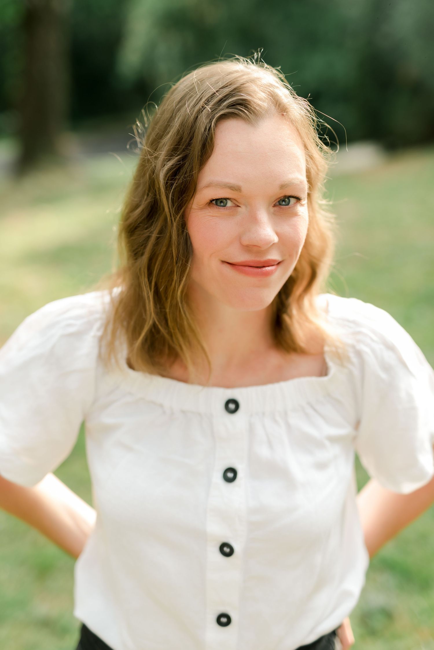 A series of outdoor portraits in a white button-up top with natural lighting.