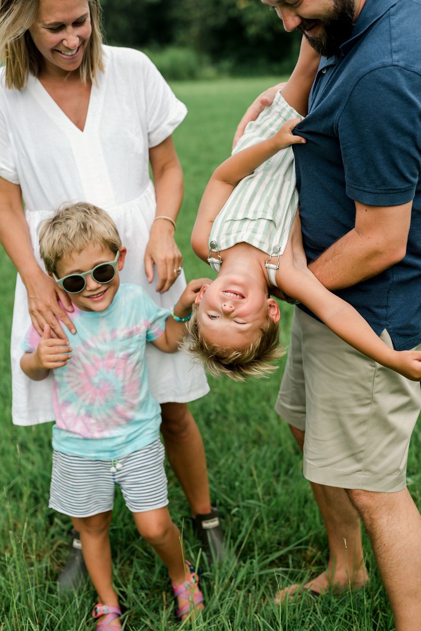 A playful sequence of photos showing a family having fun and being silly together outdoors on grass.