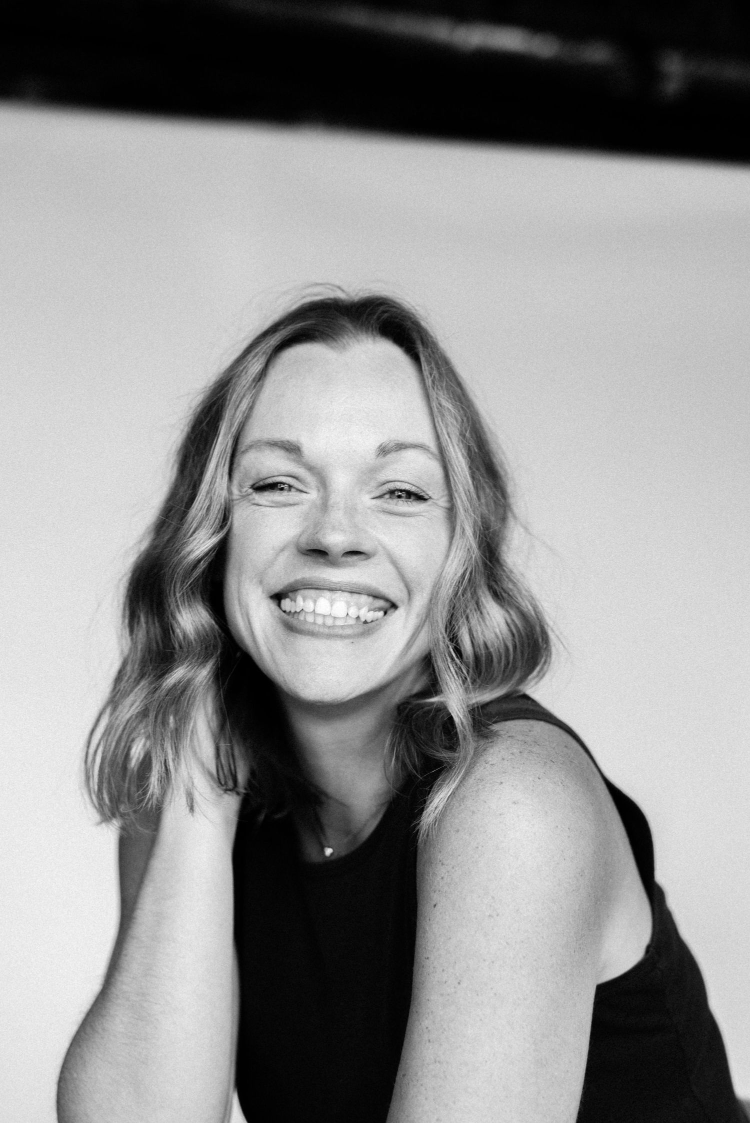 Black and white studio portraits capturing candid laughter and expressions.