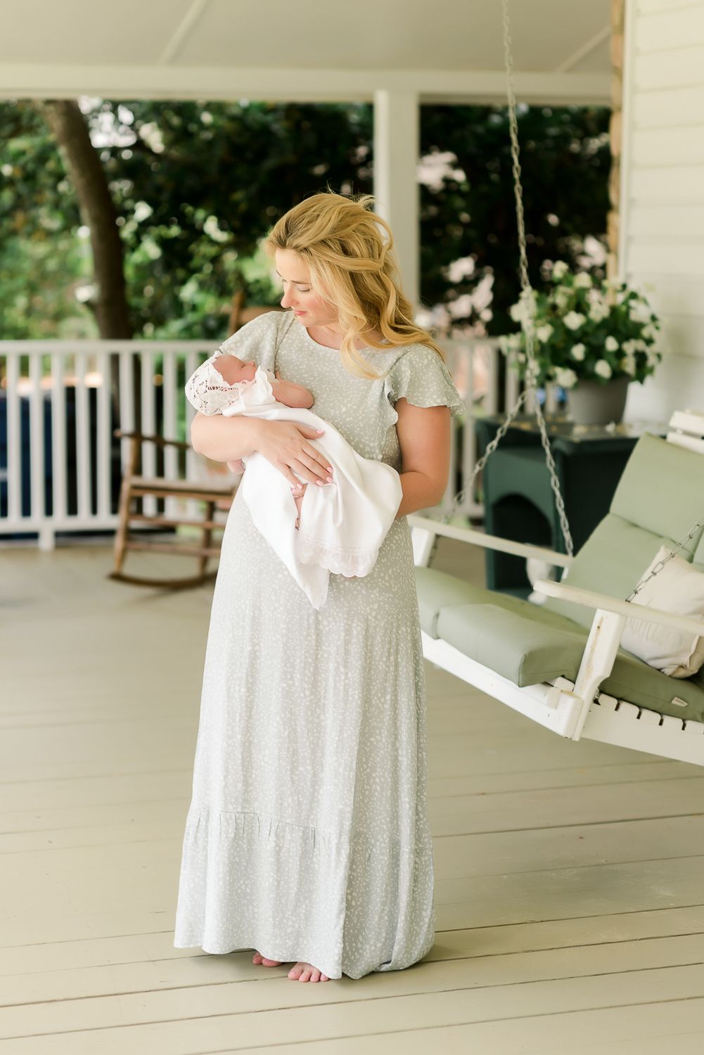 Tender moment between parent and sleeping newborn in soft natural light.