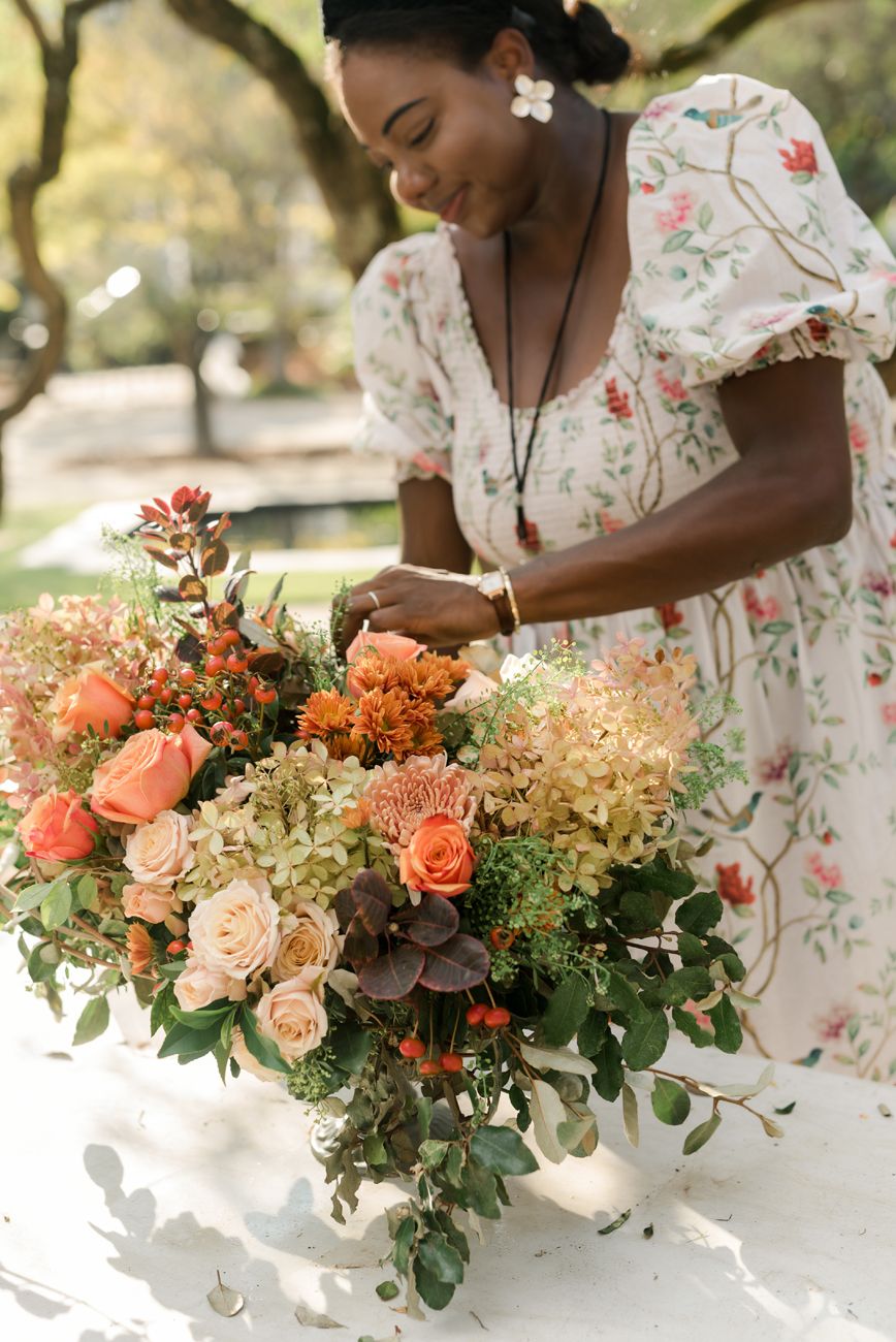 Series of floral arrangements being created with peach roses and greenery on a white surface.