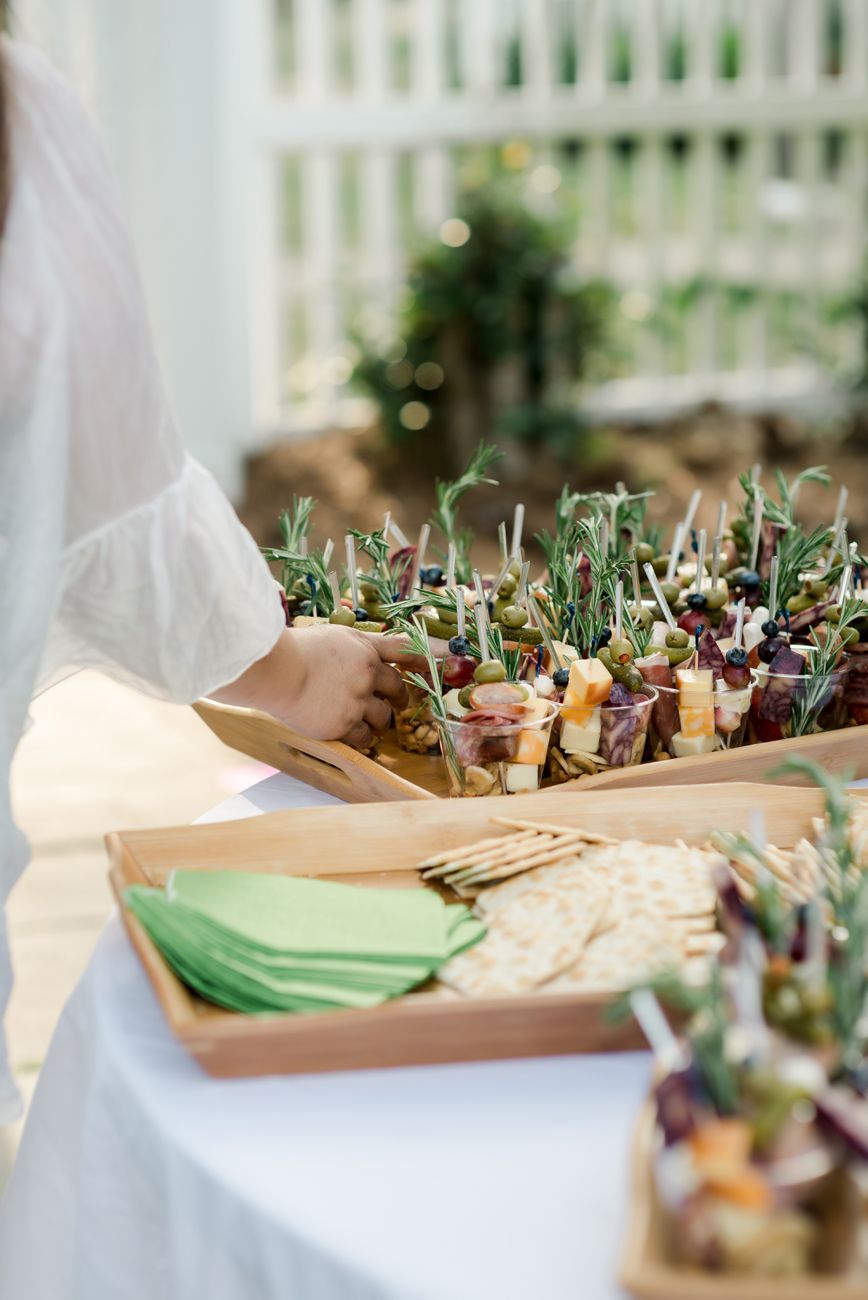 Catering tray filled with elegant appetizer bites on wooden serving boards.