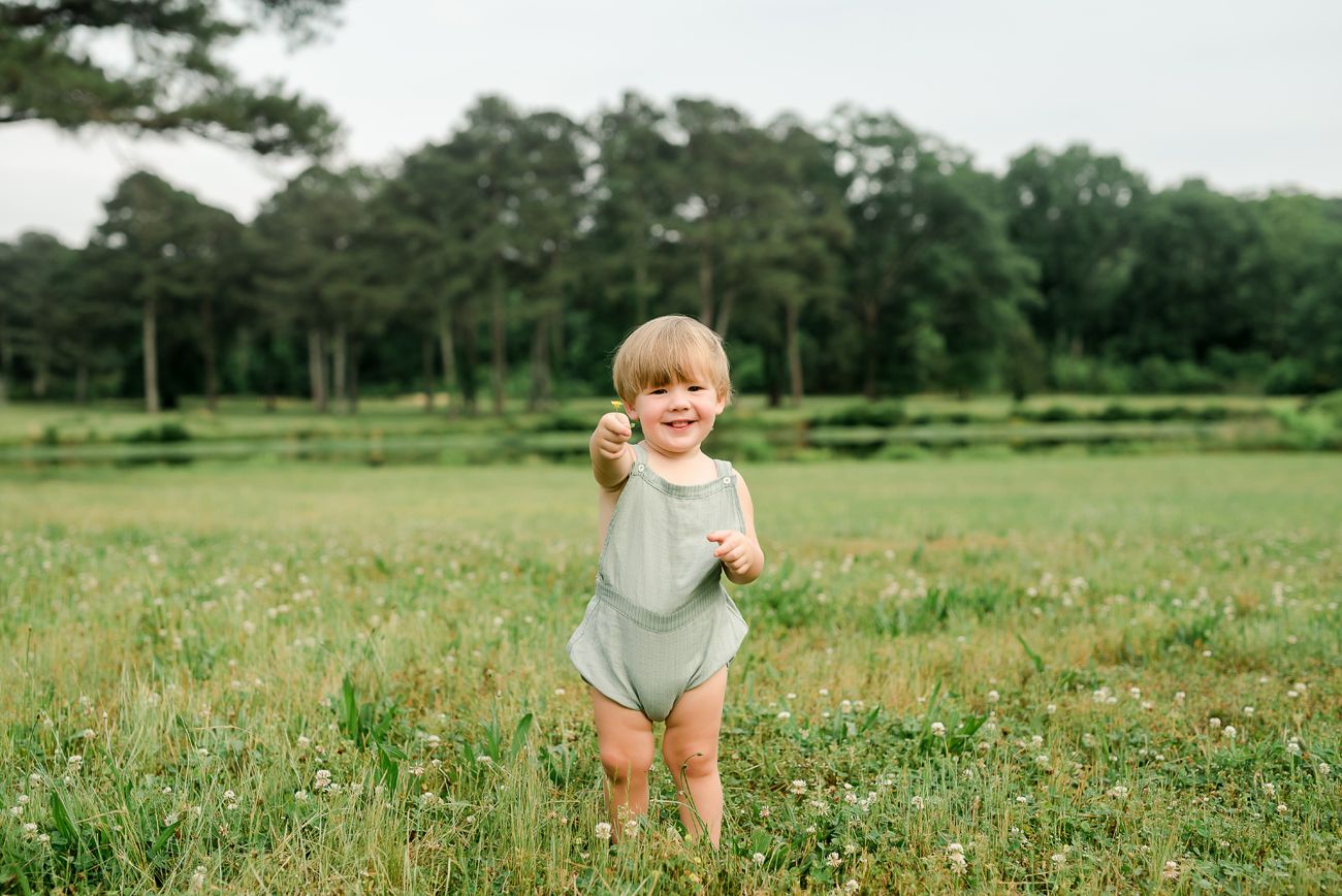 baby boy in field holding flower birmingham alabama